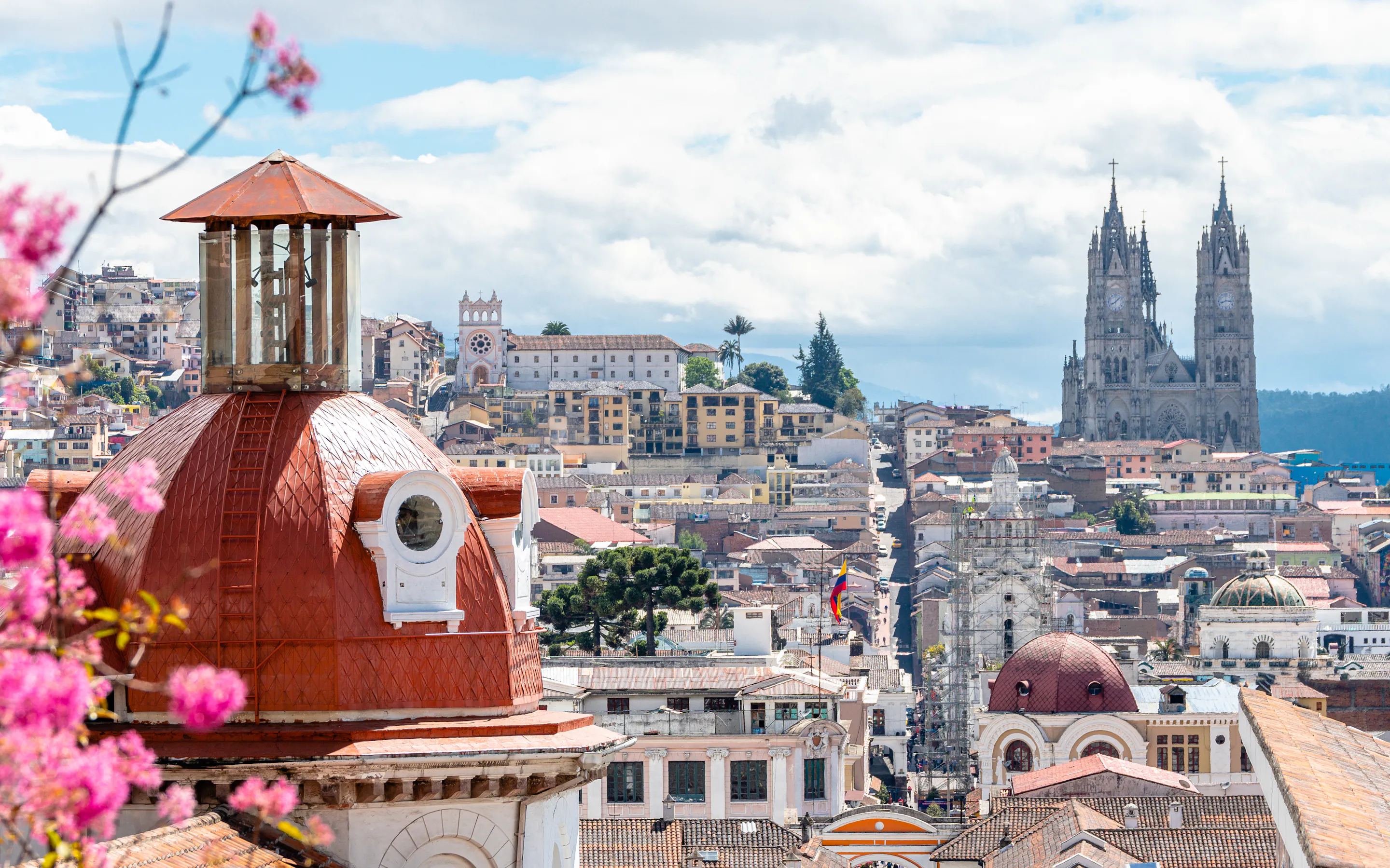 Quito's historic old town spreads across a hillside with the ornate Basilica del Voto Nacional visible.
