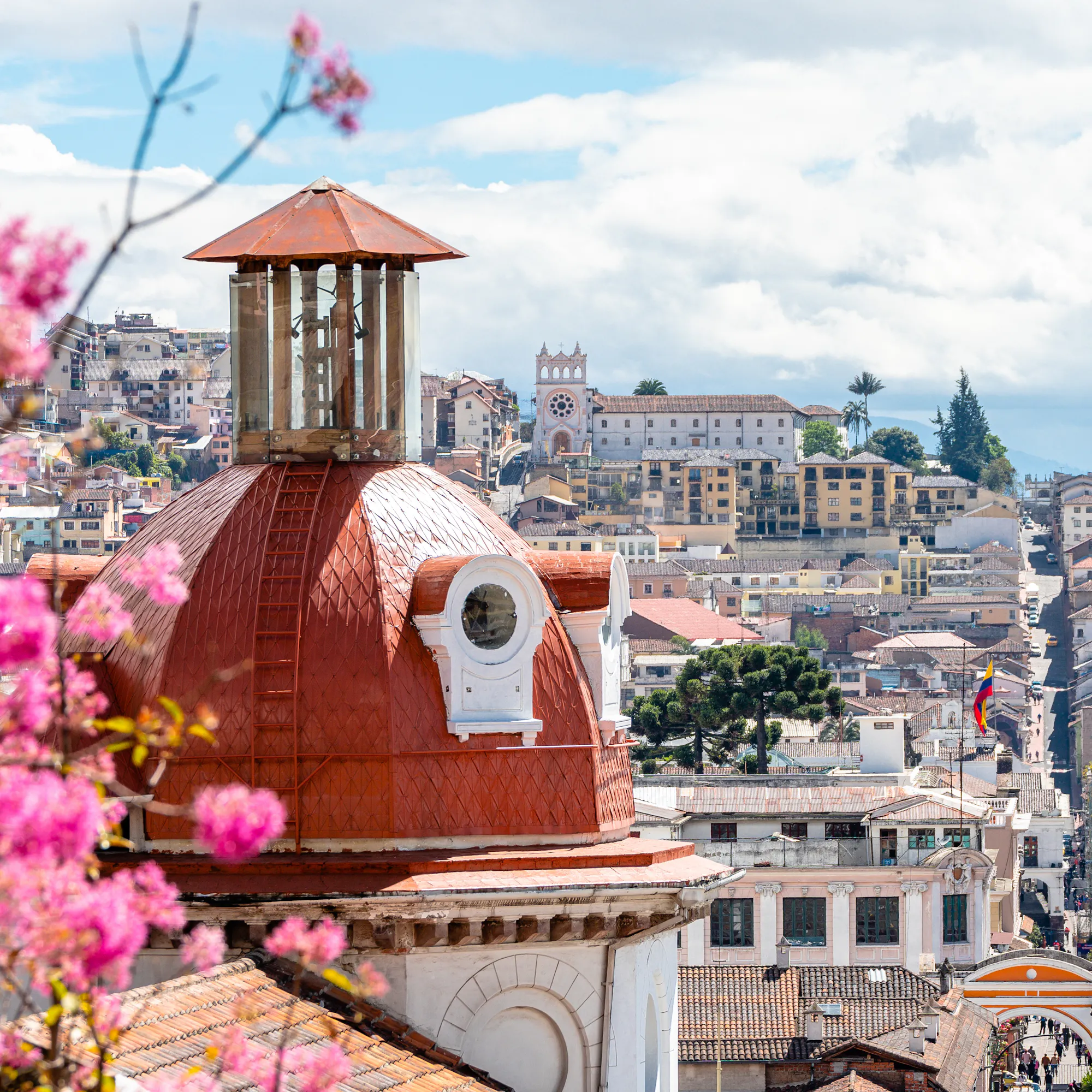 Quito's historic old town spreads across a hillside with the ornate Basilica del Voto Nacional visible.