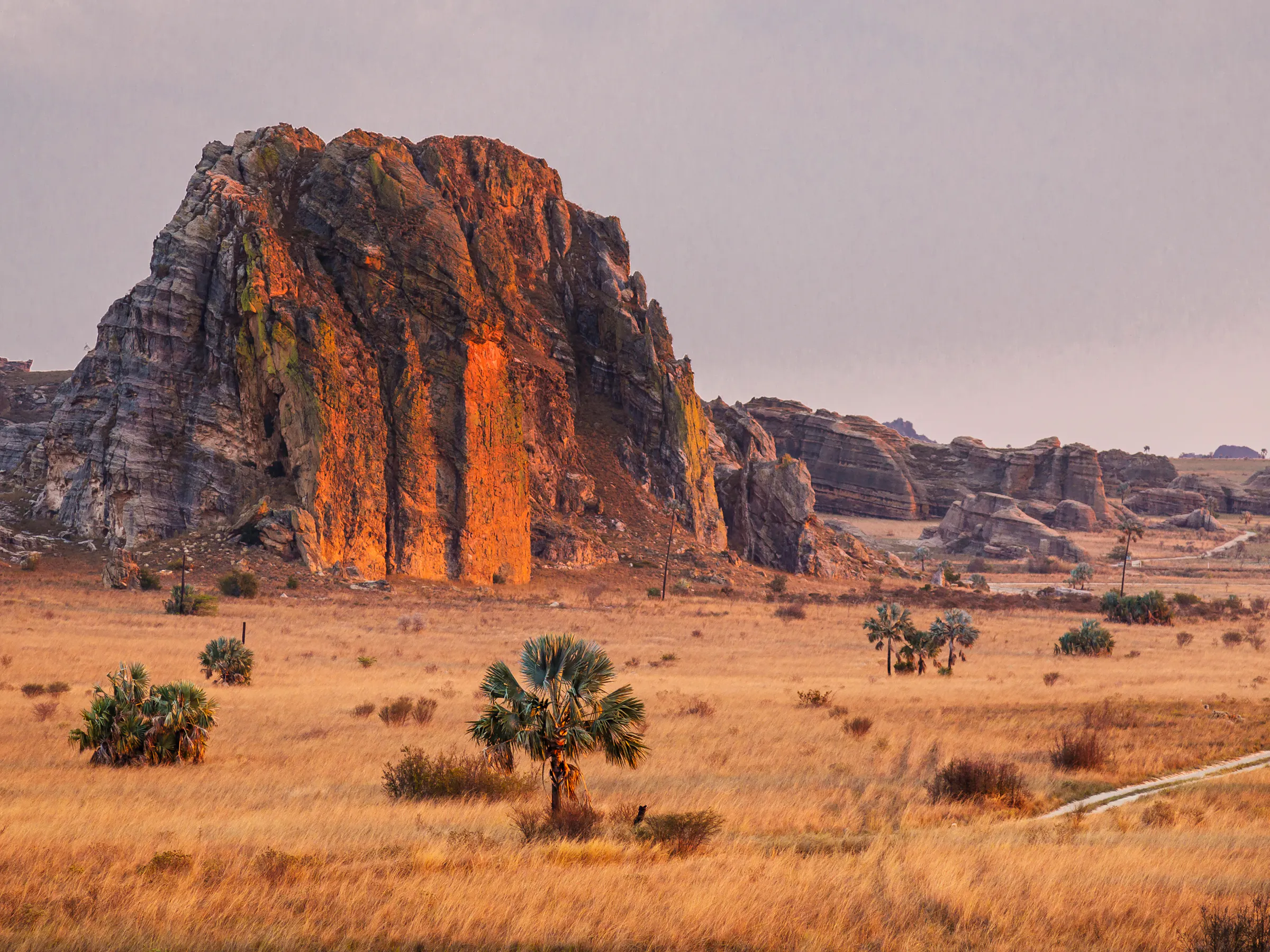 Warm sunset light bathes the dramatic sandstone formations of Isalo National Park, Madagascar.
