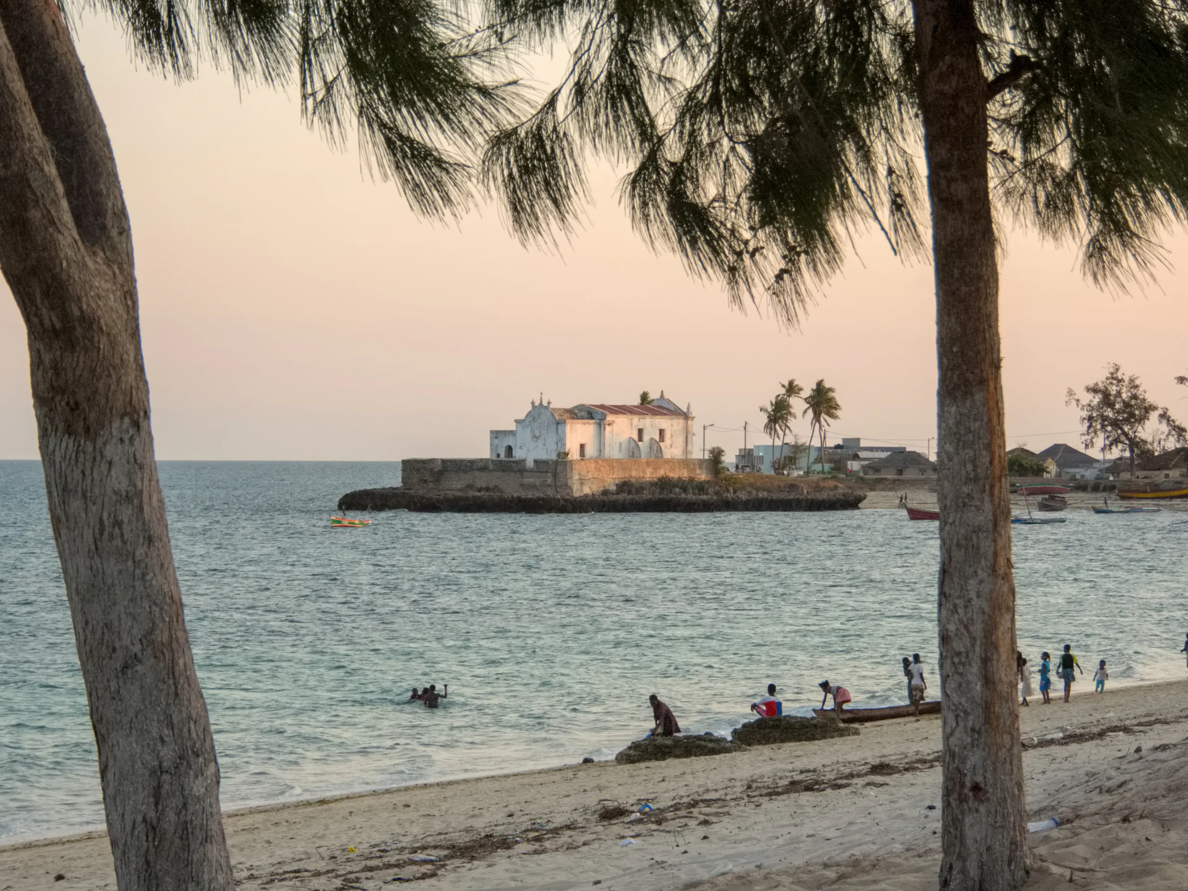 A narrow street on Ilha de Moçambique is lined with weathered colonial-era buildings.