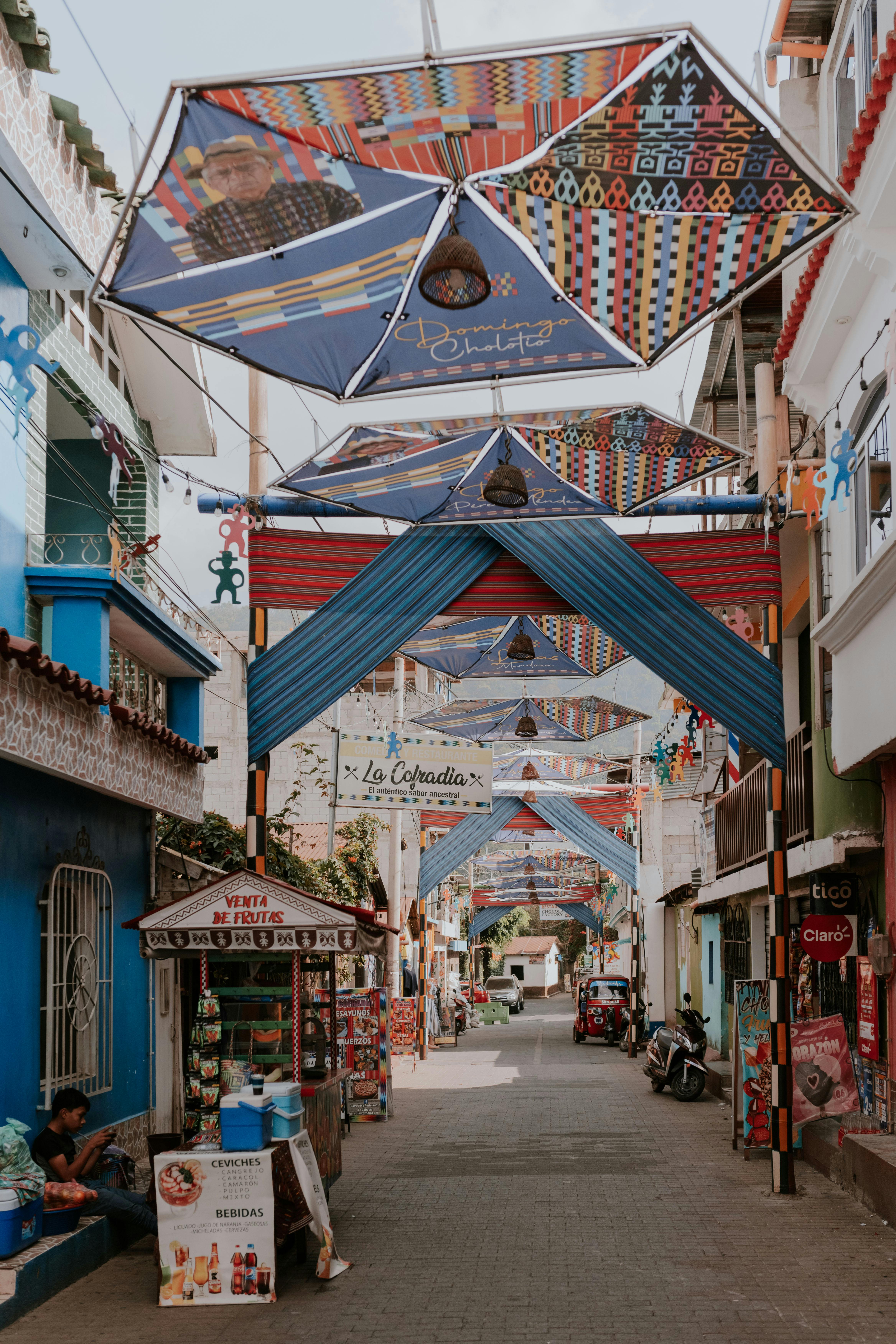 A colorful painted market hall with a patterned ceiling is lined with stalls in Santa Marta.
