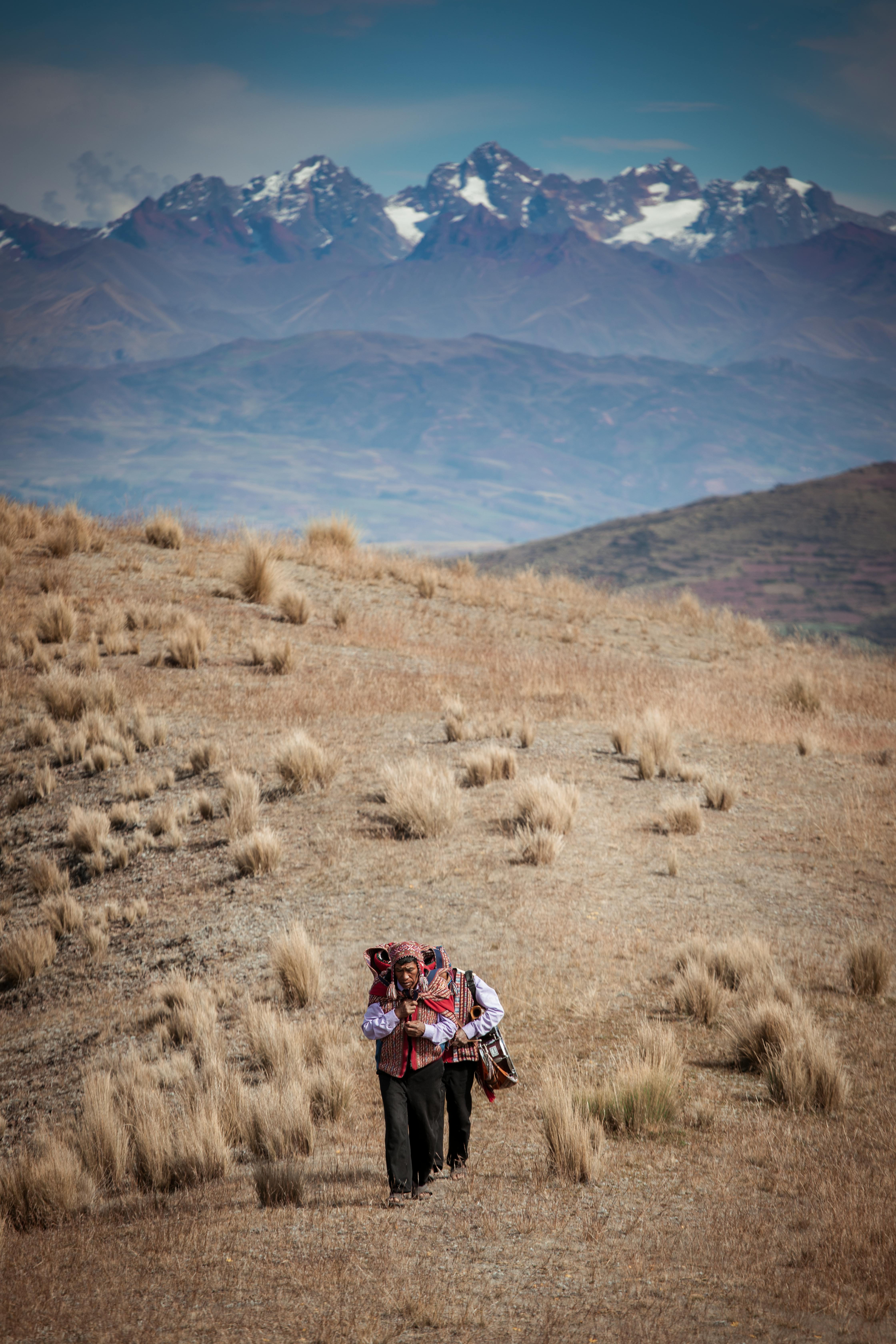Aerial view of two men walking through the Andean valley.