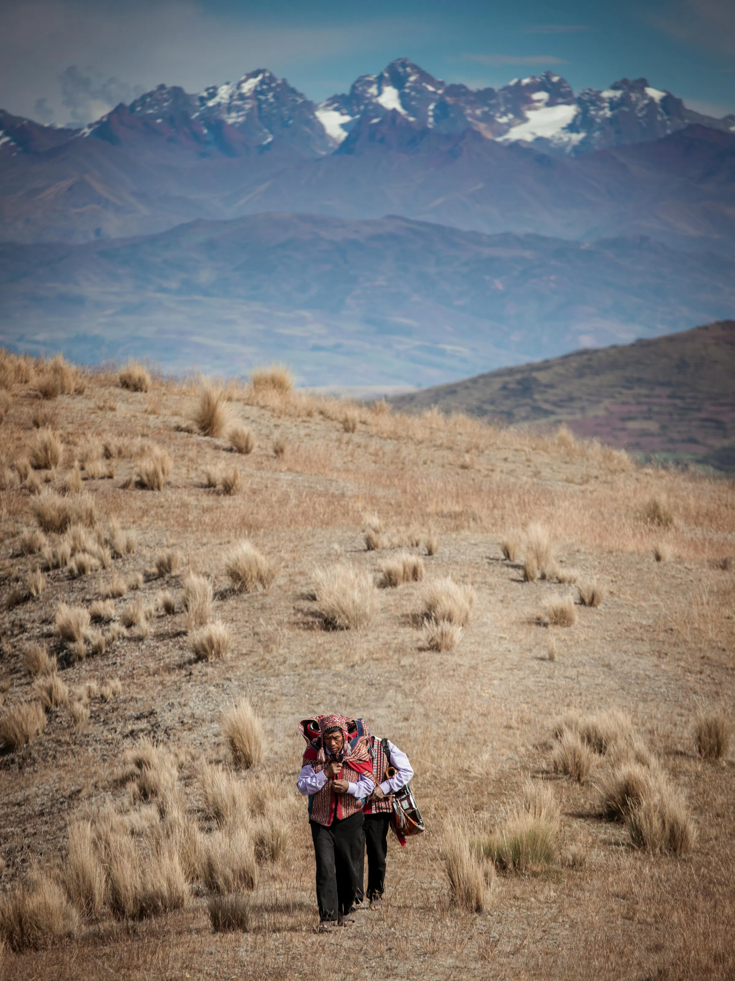 Aerial view of two men walking through the Andean valley.