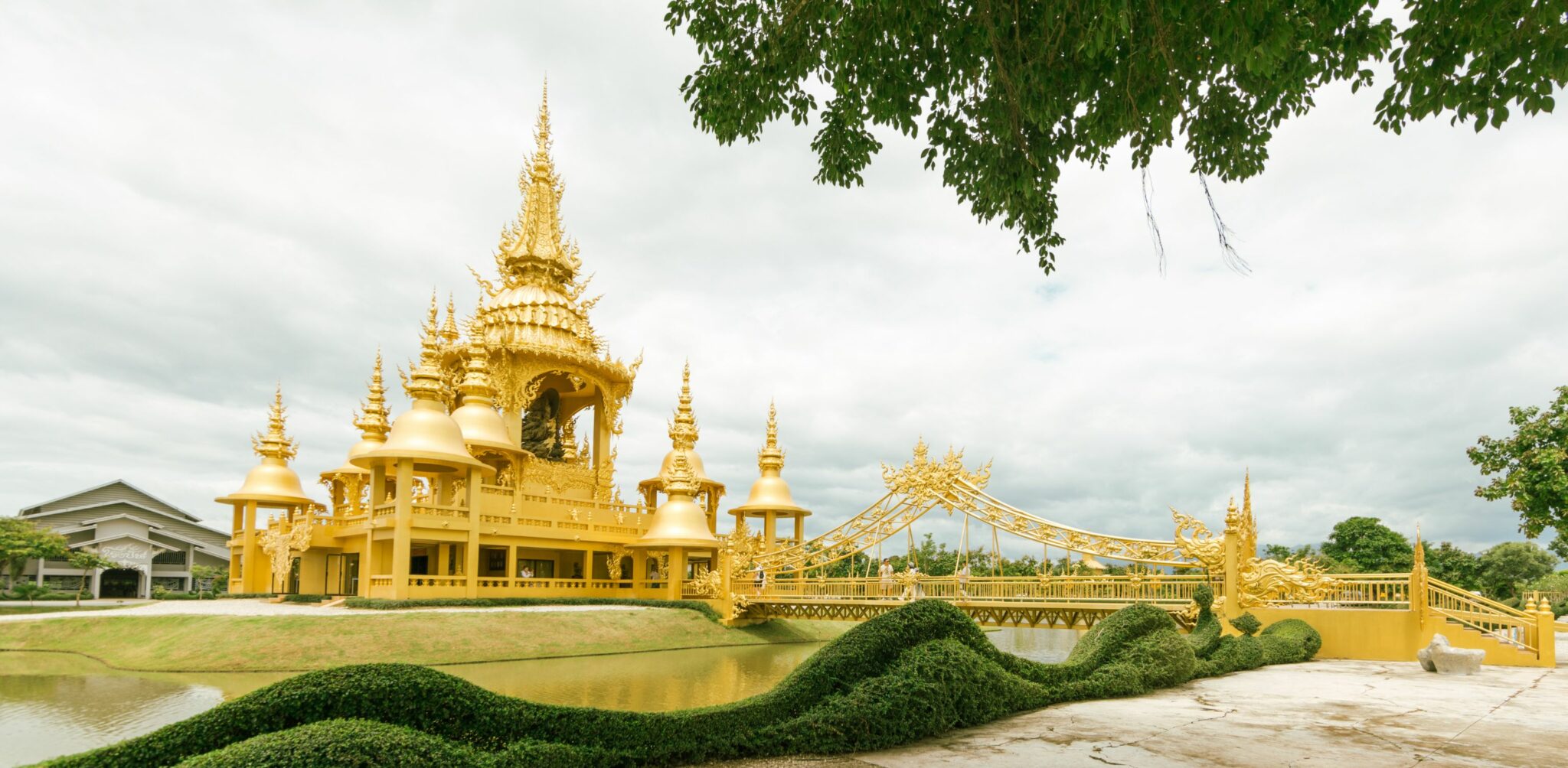 The gleaming white spires and ornate details of the White Temple in Chiang Rai under blue sky.