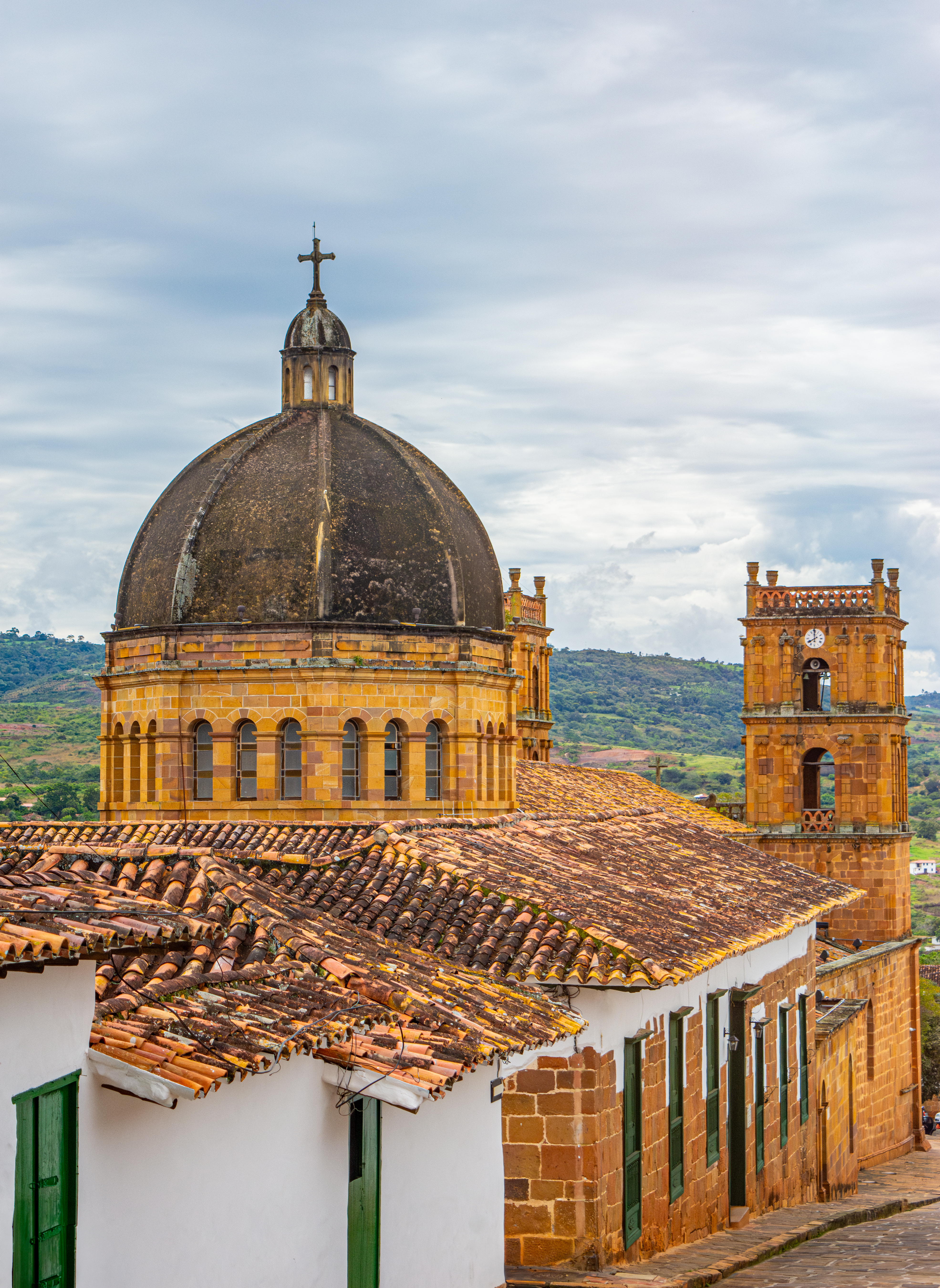 The ornate stone dome and tile rooftop of a colonial church dominate the skyline of Barichara.