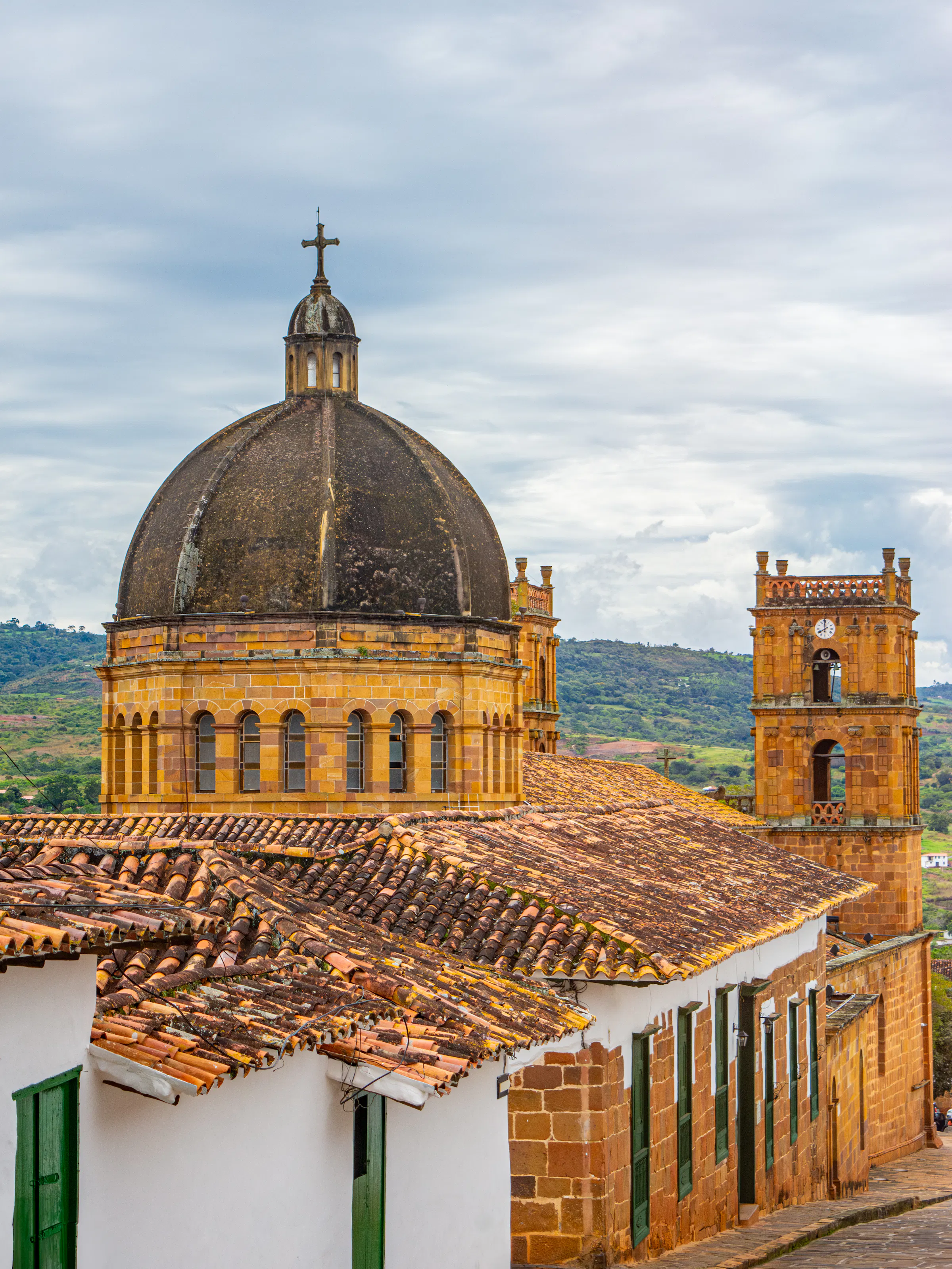 The ornate stone dome and tile rooftop of a colonial church dominate the skyline of Barichara.