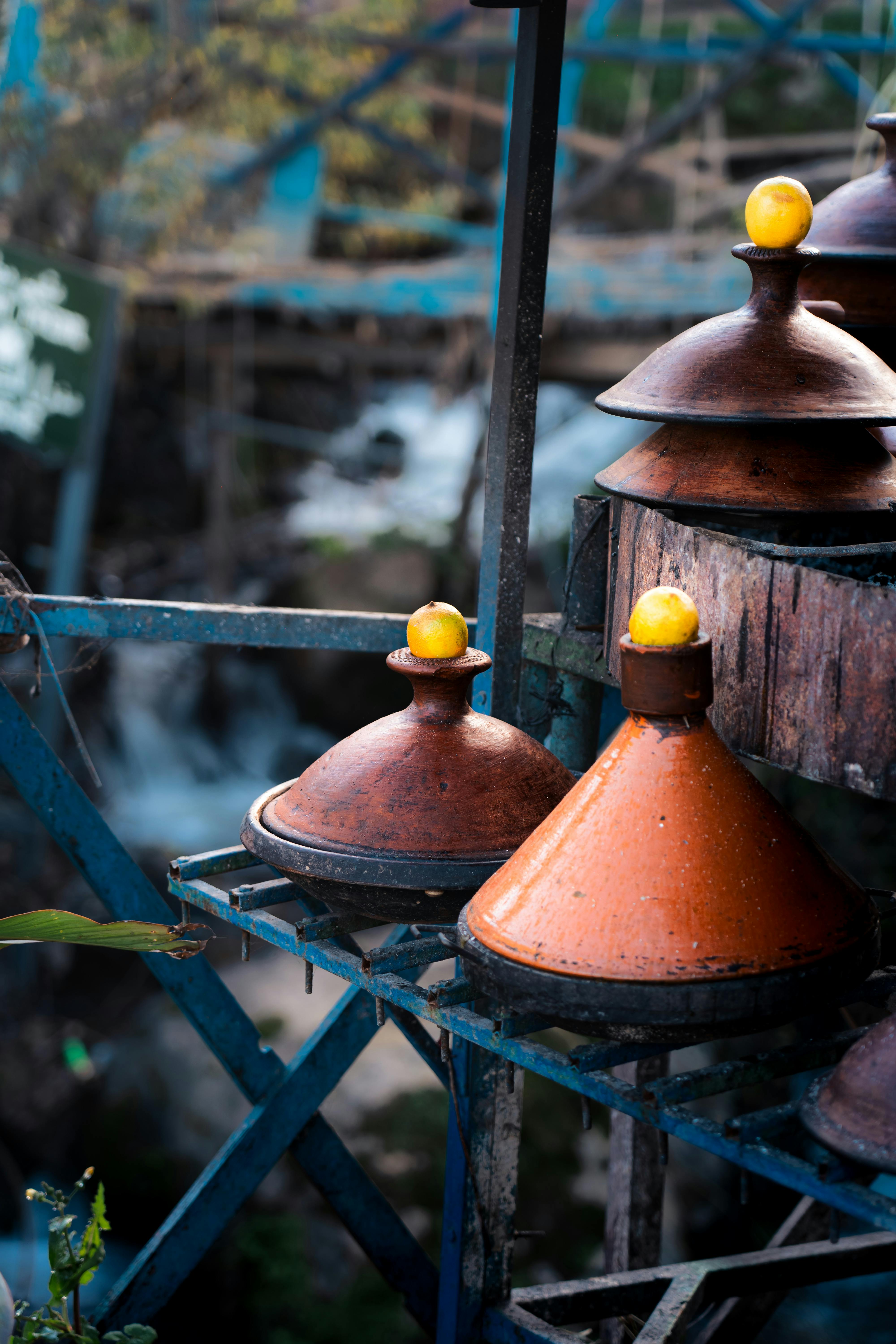 Brightly colored clay tagine pots hang in rows above a doorway in a market in Chefchaouen.
