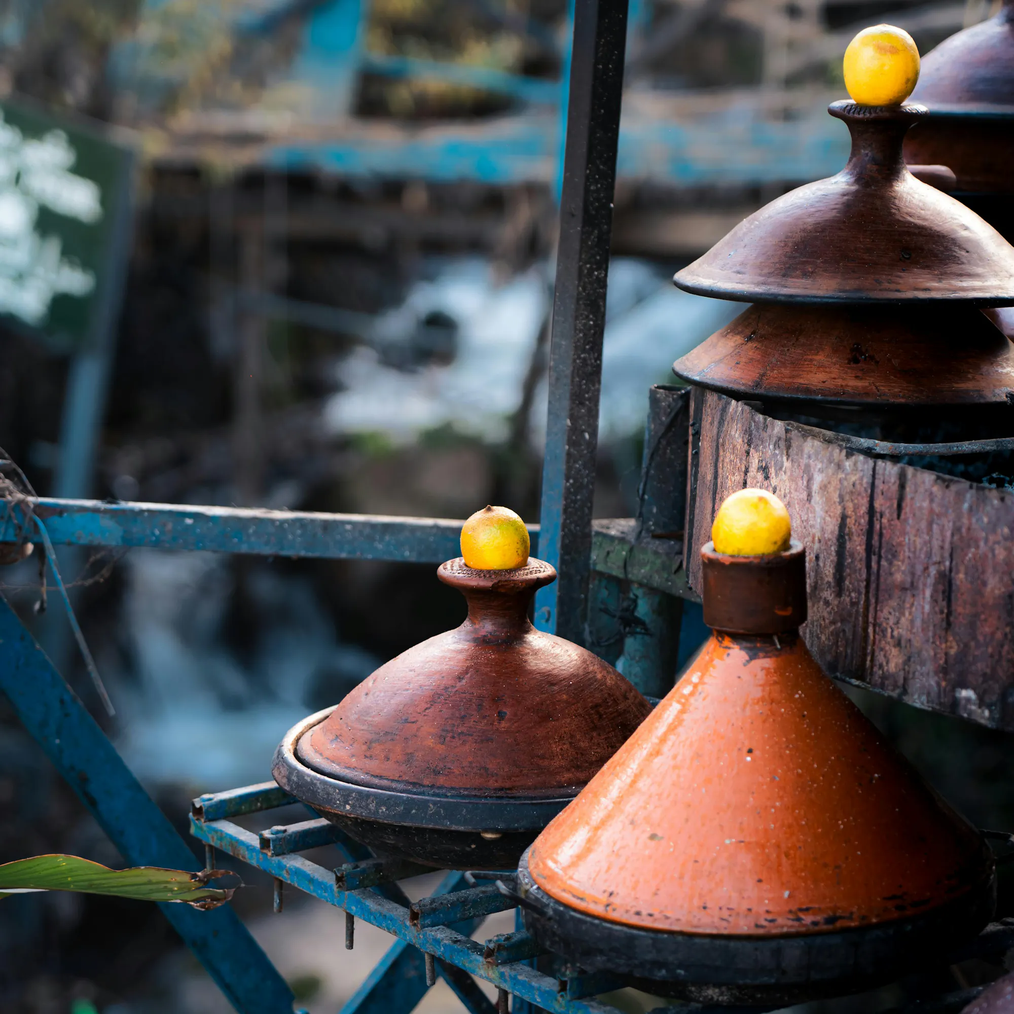 Brightly colored clay tagine pots hang in rows above a doorway in a market in Chefchaouen.
