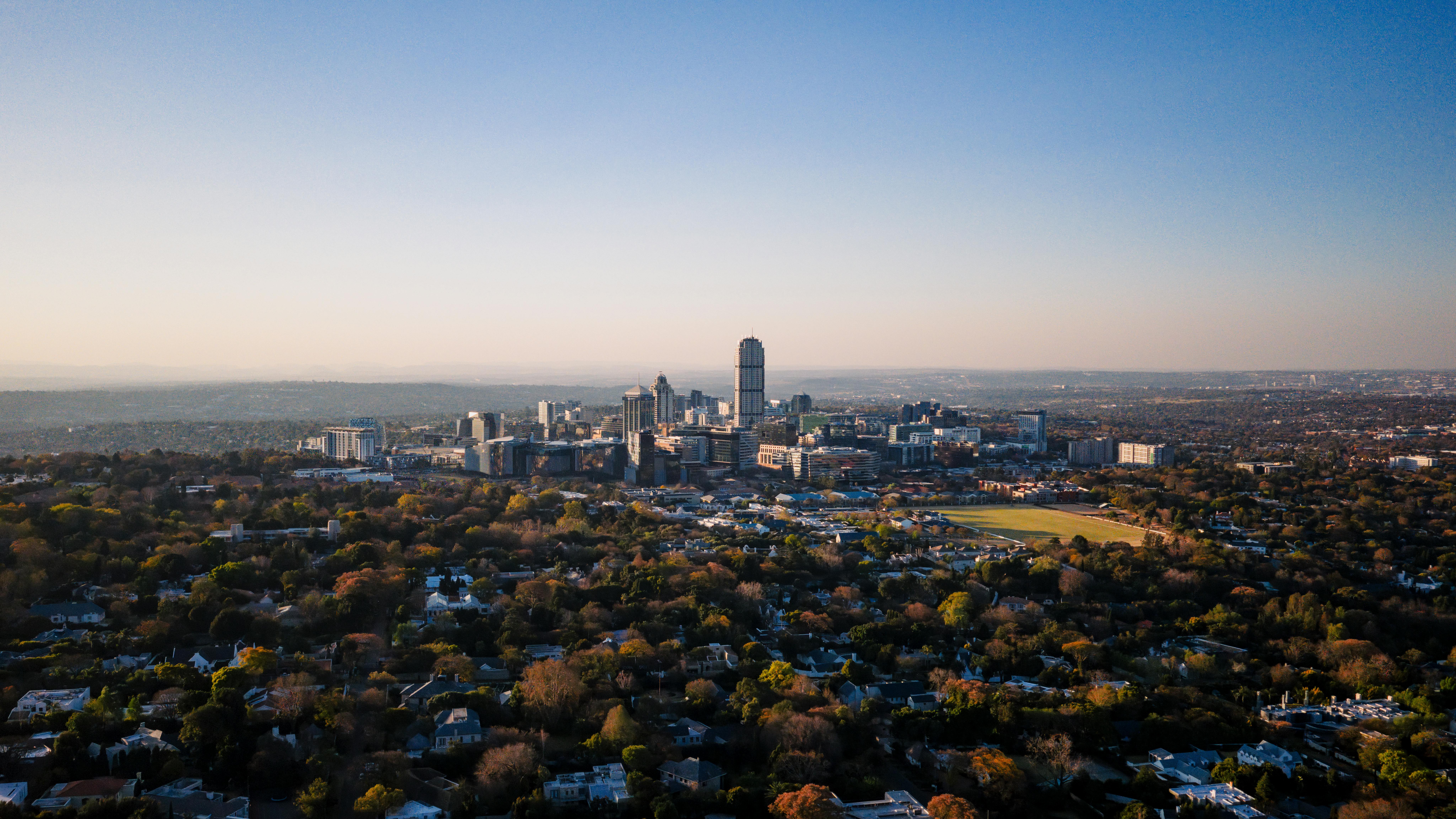 Johannesburg's downtown skyline is seen from a distance under a wide overcast sky.