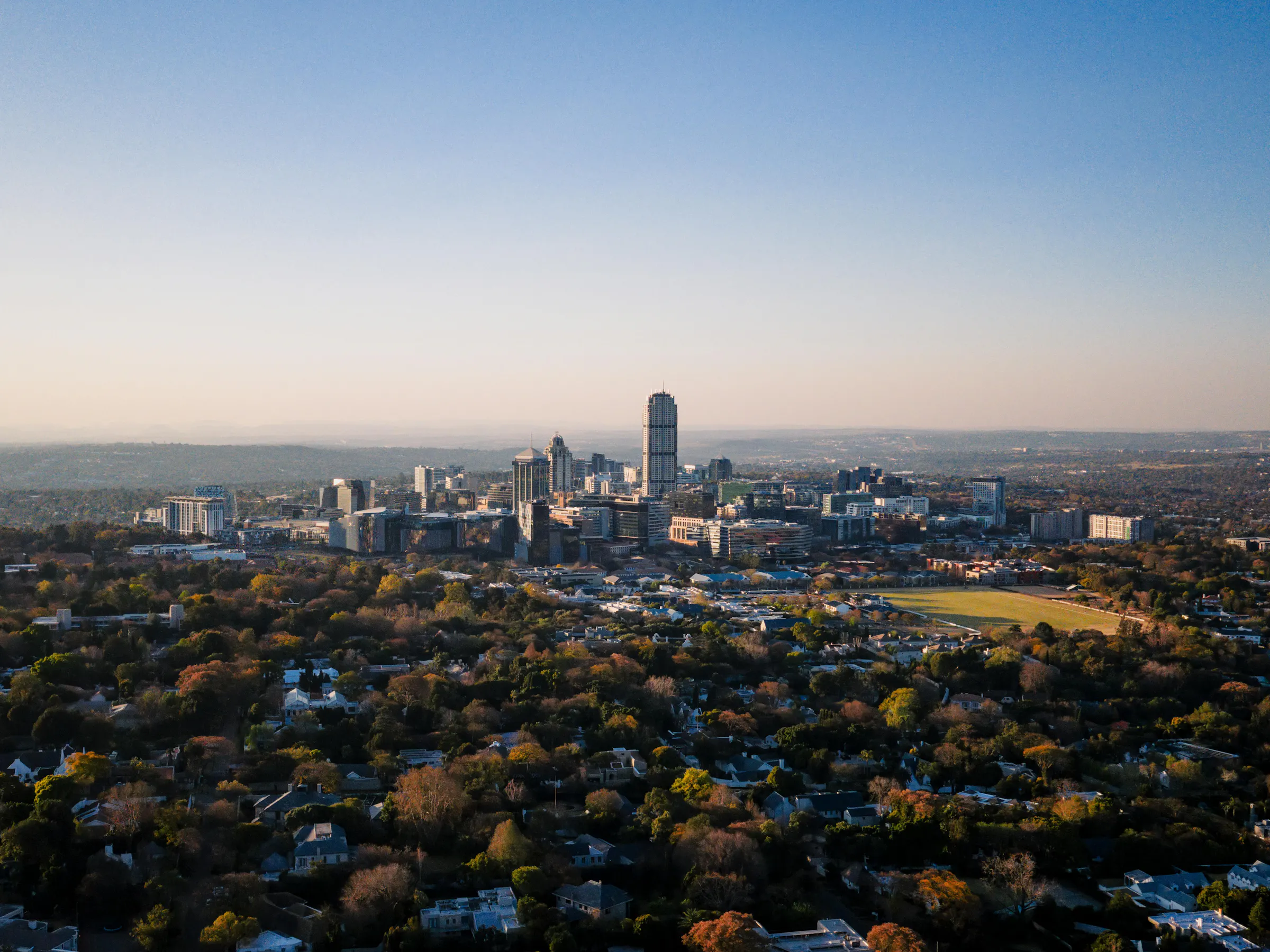 Johannesburg's downtown skyline is seen from a distance under a wide overcast sky.