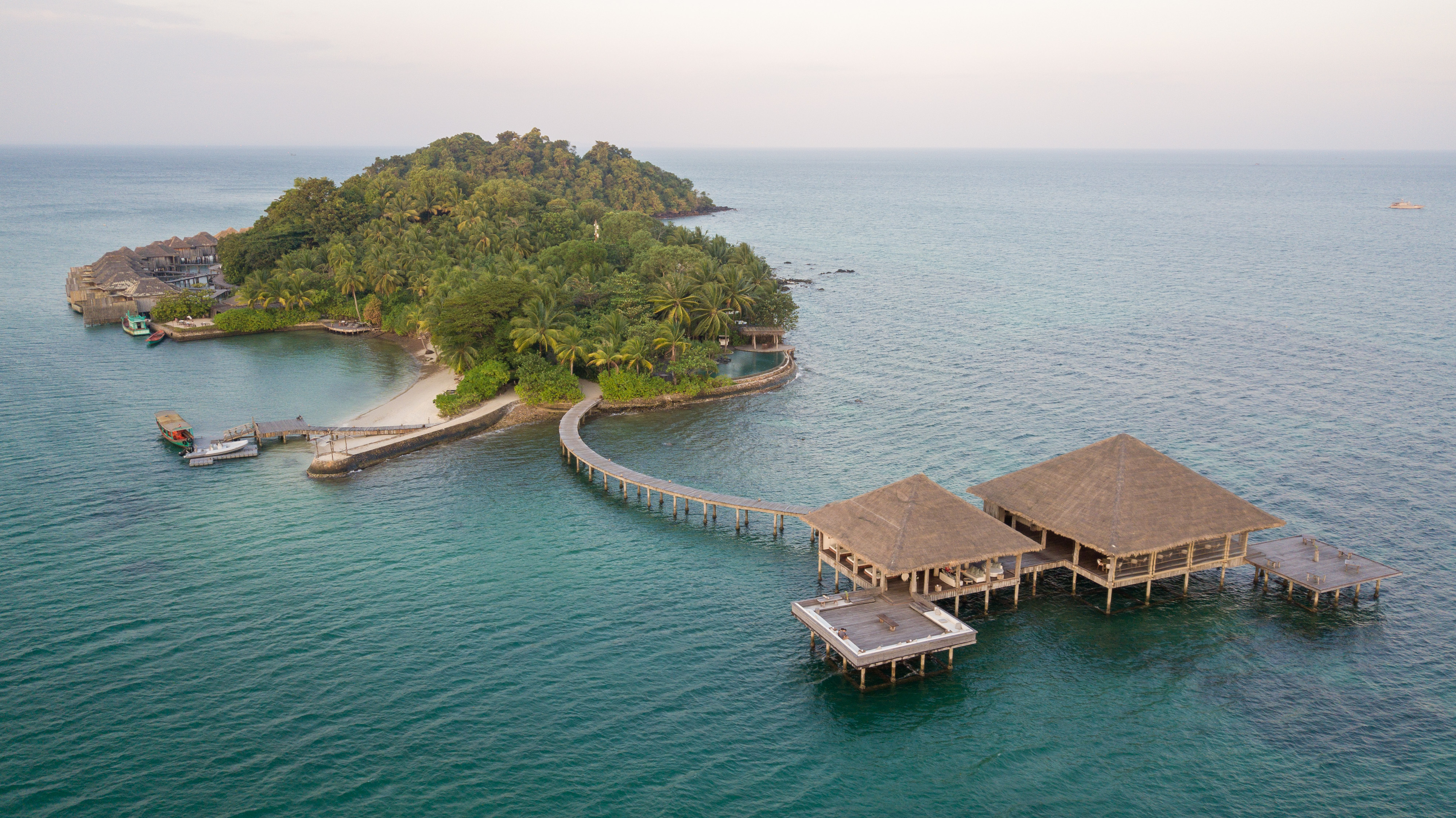 Aerial view of a densely forested island surrounded by vivid turquoise ocean near Koh Rong.