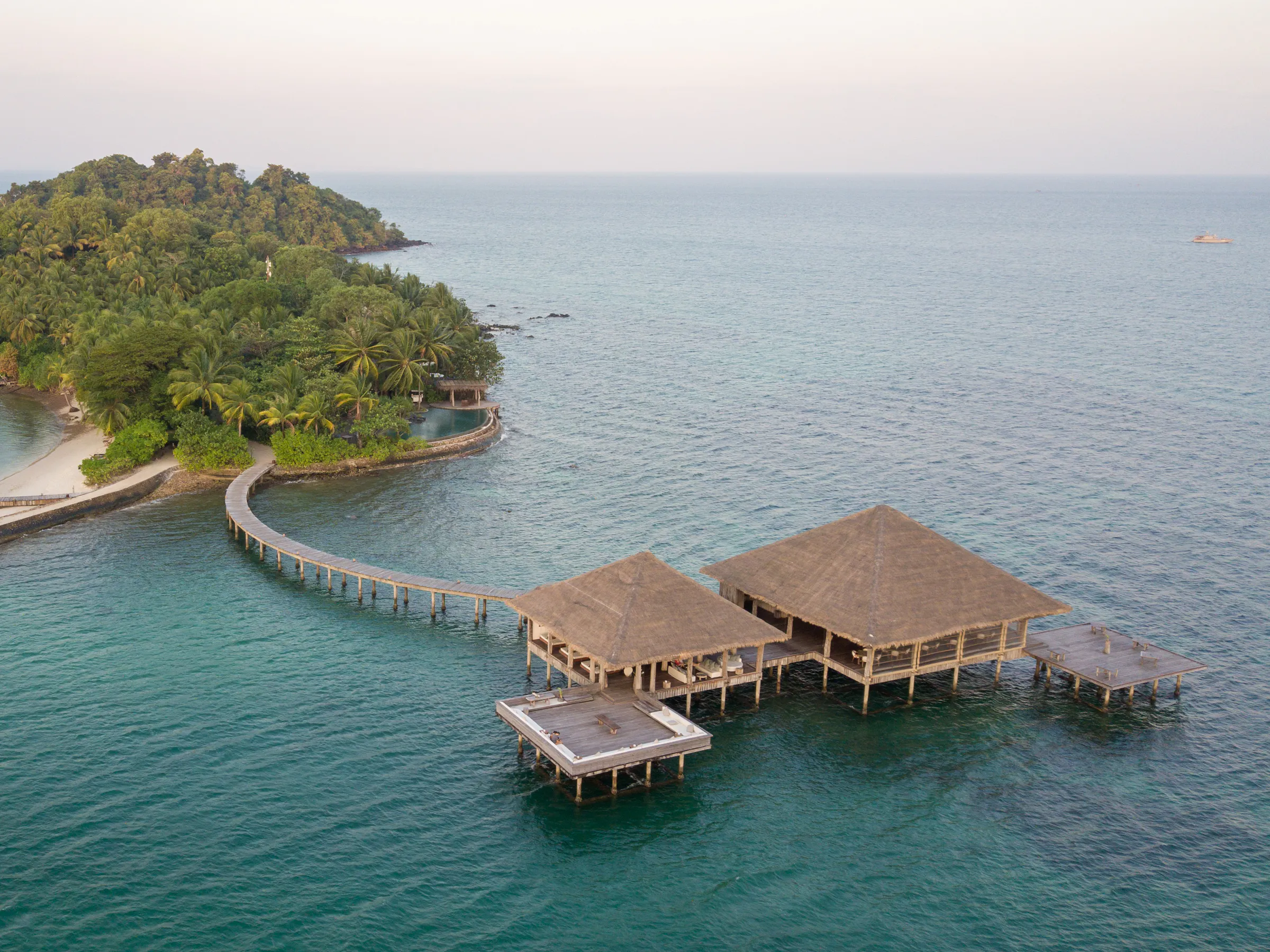 Aerial view of a densely forested island surrounded by vivid turquoise ocean near Koh Rong.