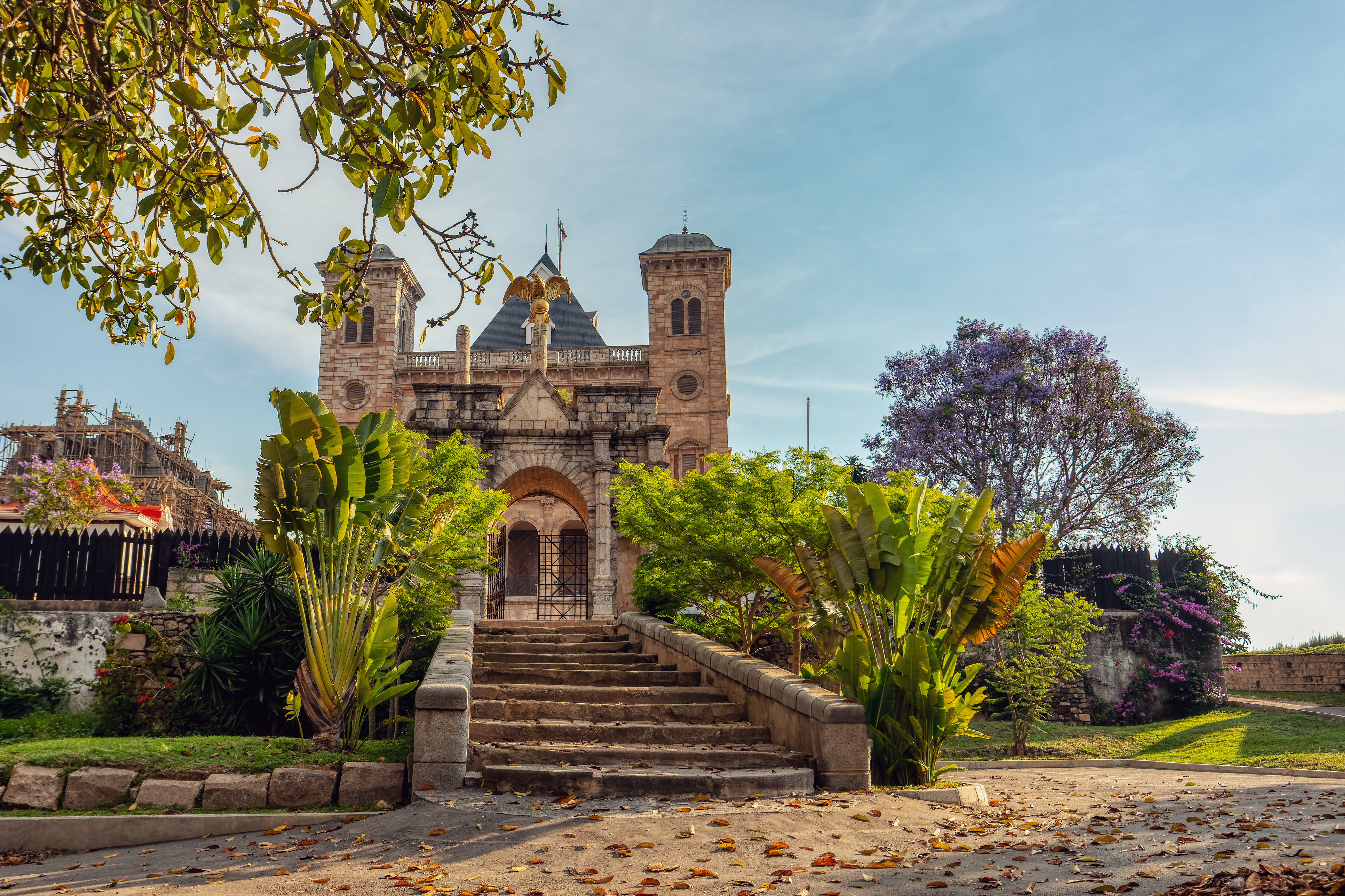 A colonial-era stone church and monument stand amid flower-filled gardens in Antananarivo.