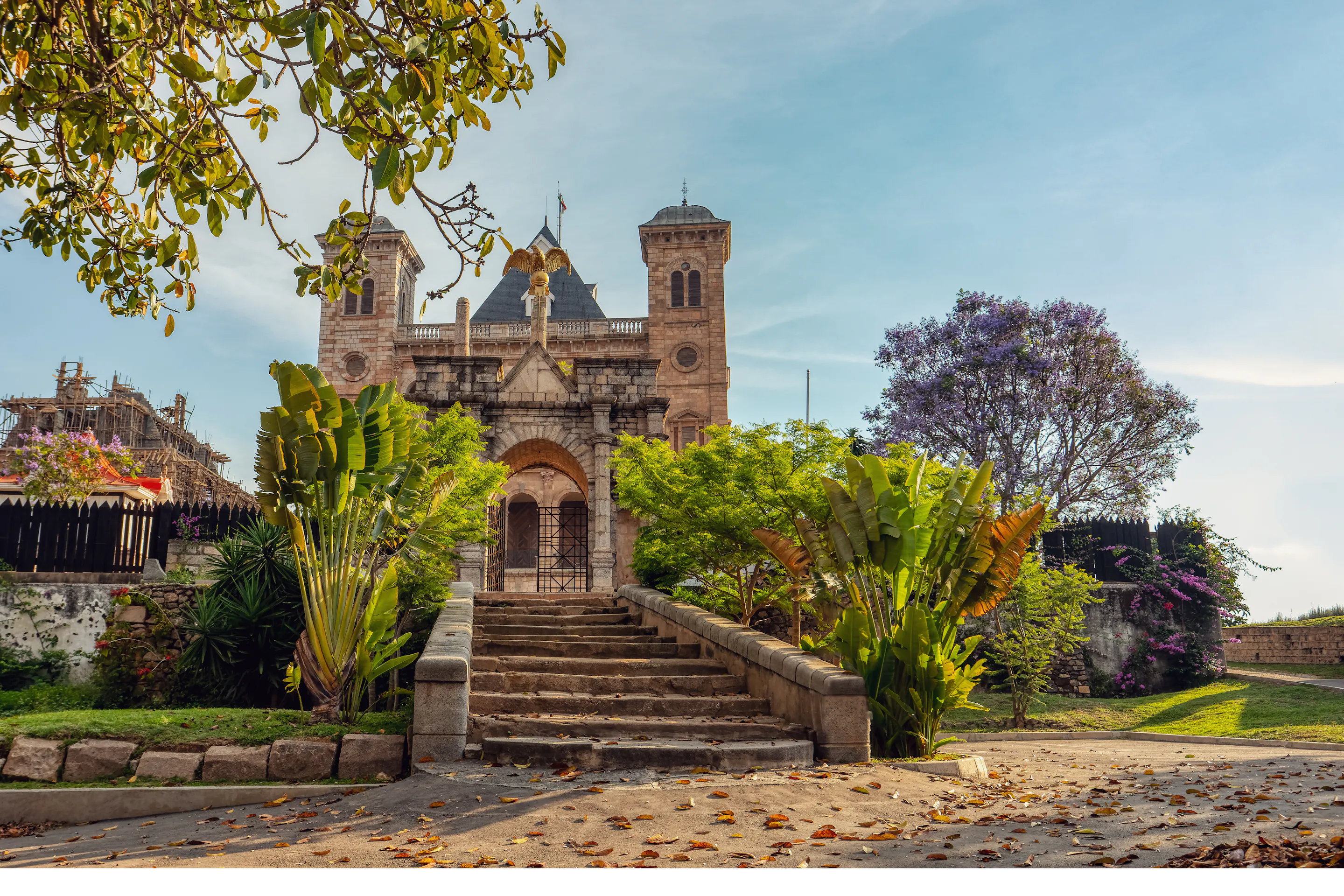 A colonial-era stone church and monument stand amid flower-filled gardens in Antananarivo.