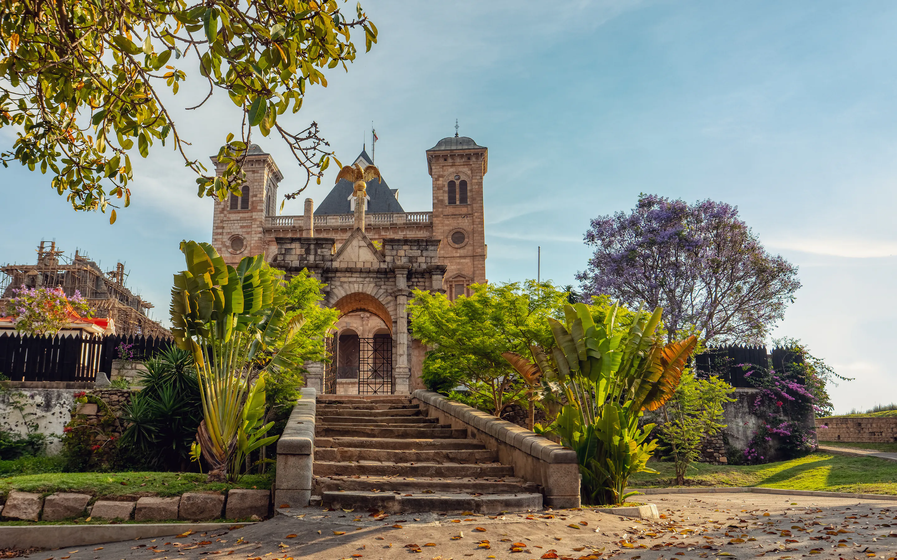 A colonial-era stone church and monument stand amid flower-filled gardens in Antananarivo.