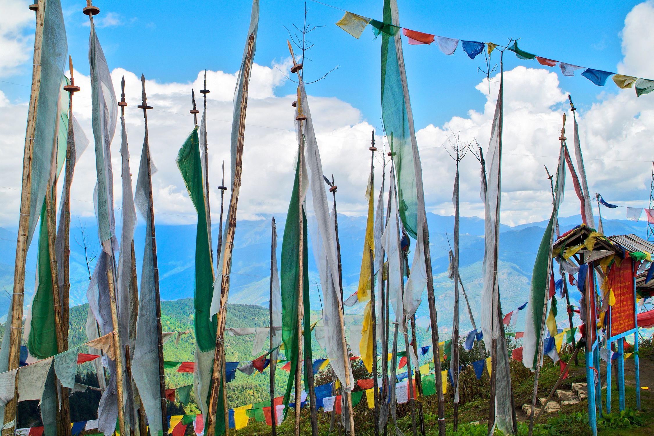A line of prayer flags in front of a blue sky in the Haa Valley, Bhutan.
