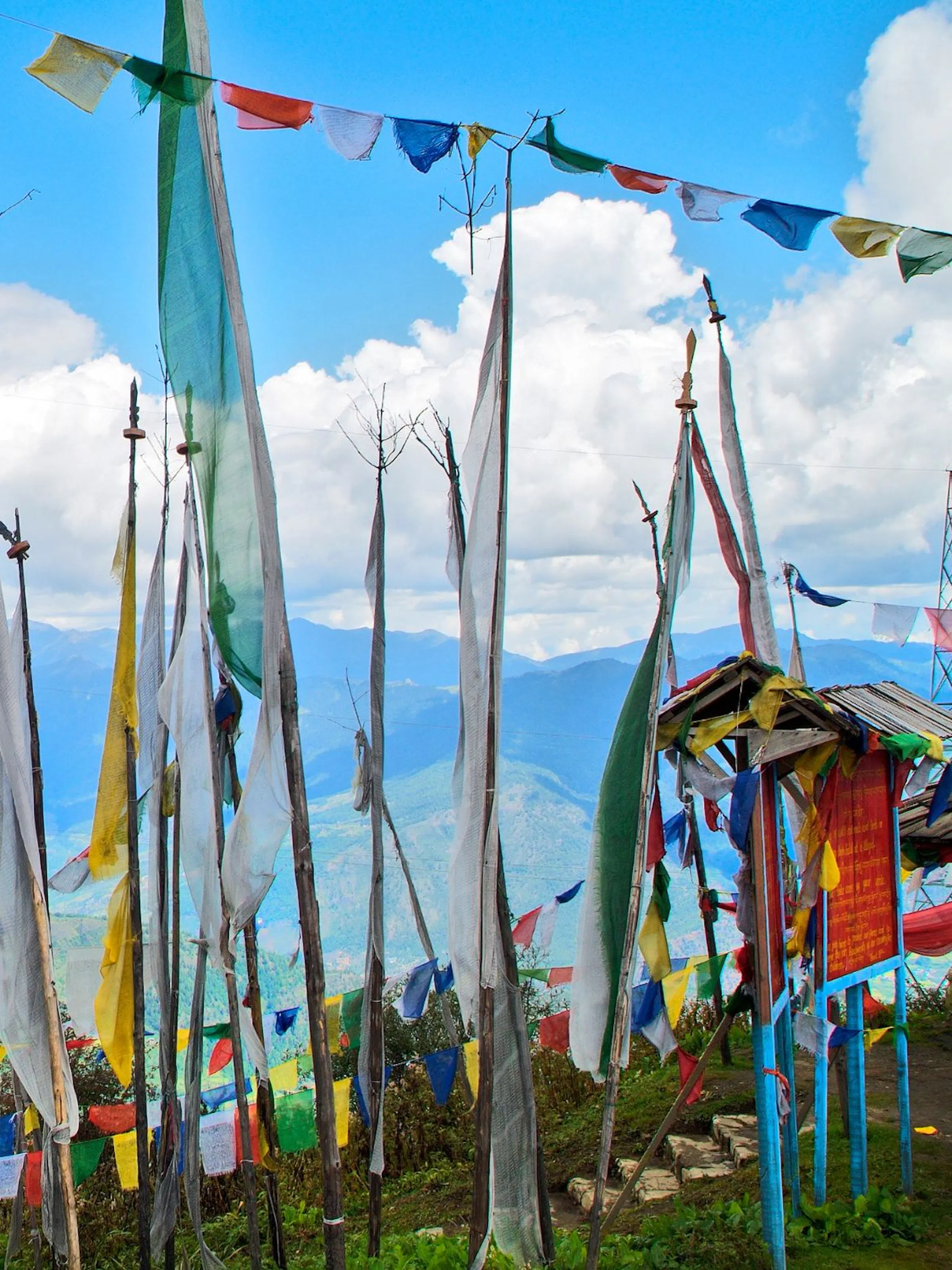 A line of prayer flags in front of a blue sky in the Haa Valley, Bhutan.