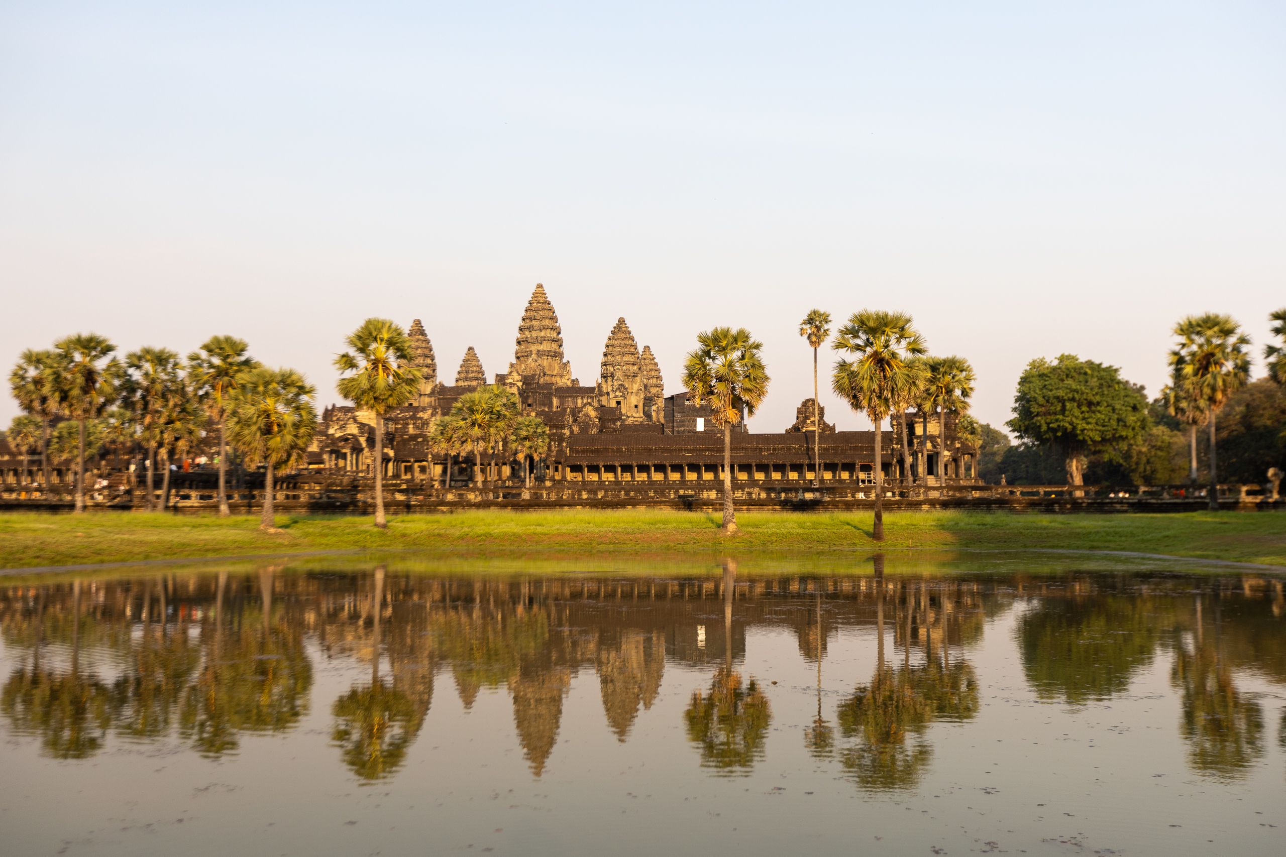 Angkor Wat reflected in moat with palm trees, Siem Reap Cambodia
