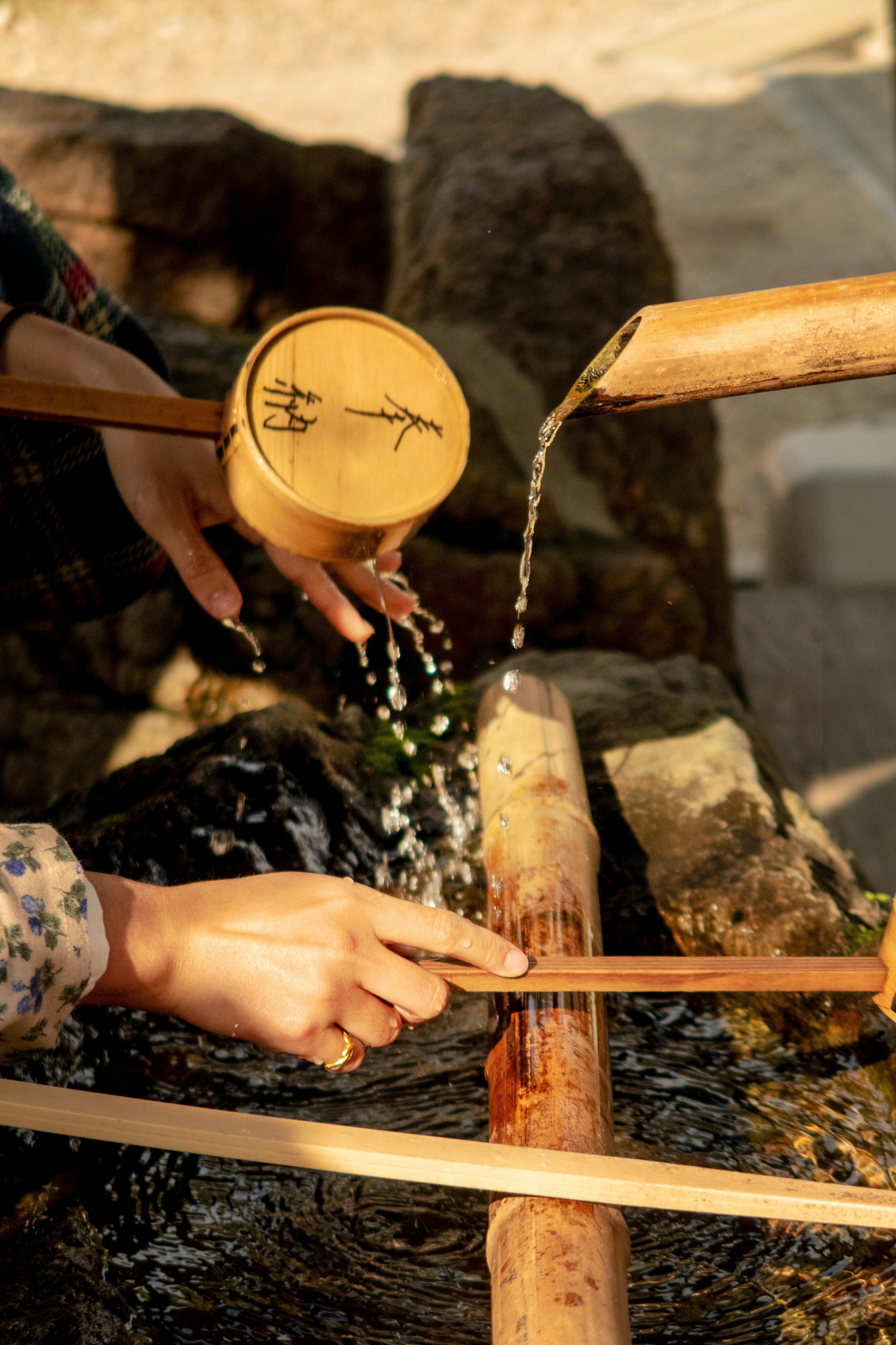 Ritual hand purification at bamboo temizuya fountain, Kyoto shrine