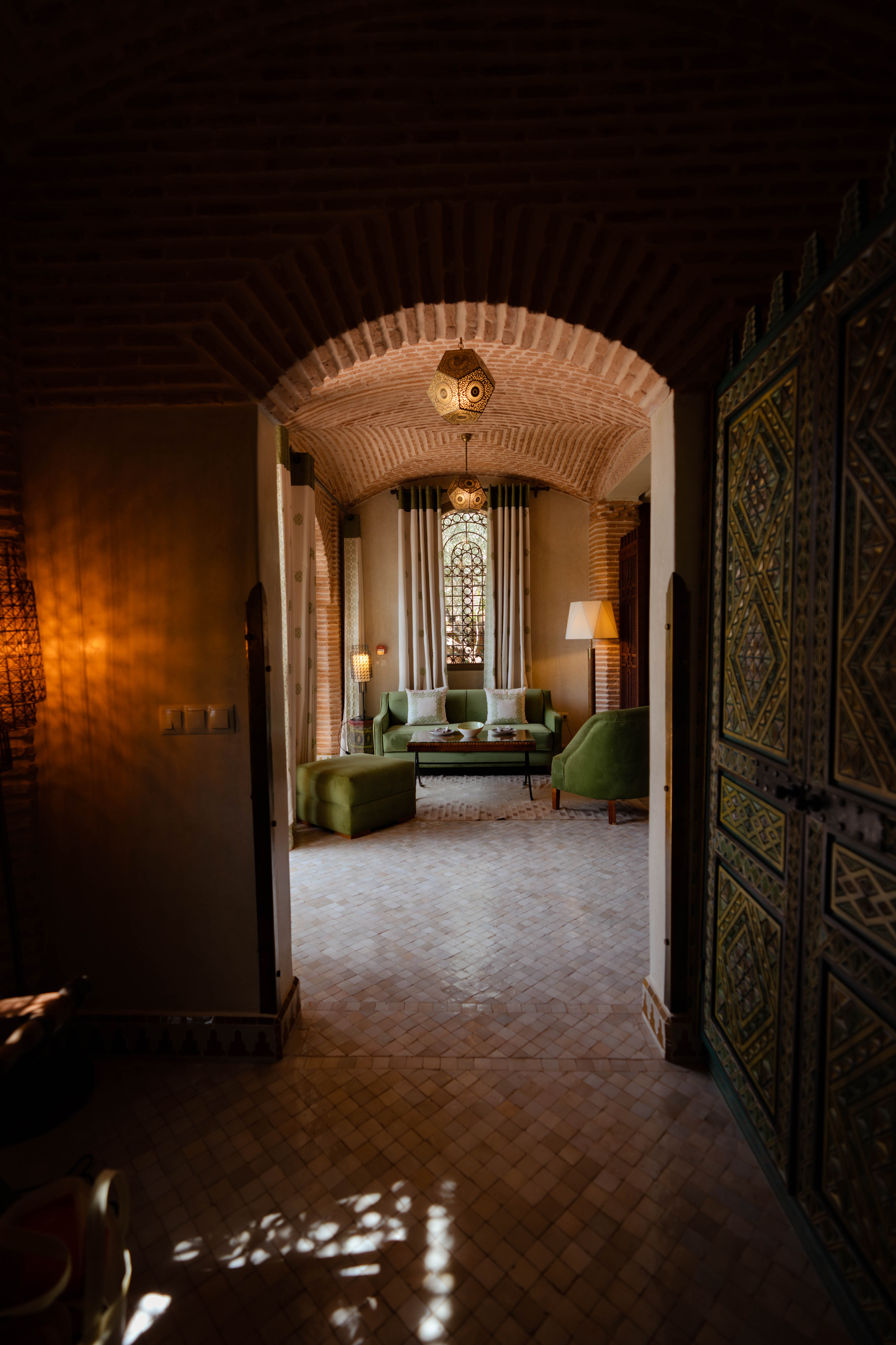 Ornate Moroccan riad interior with arched brick doorway, Morocco