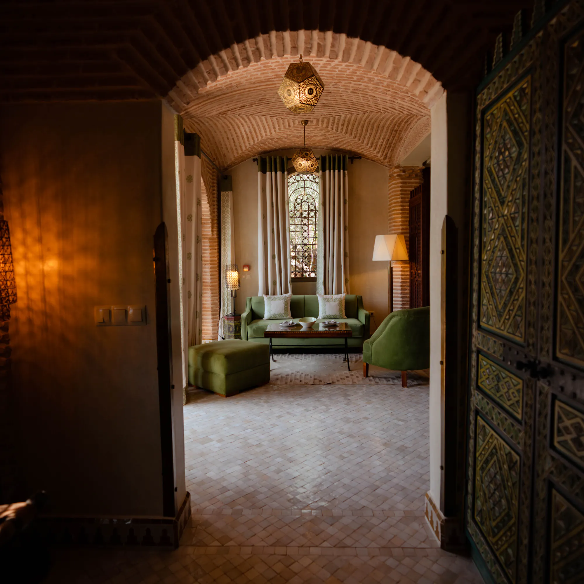 Ornate Moroccan riad interior with arched brick doorway, Morocco