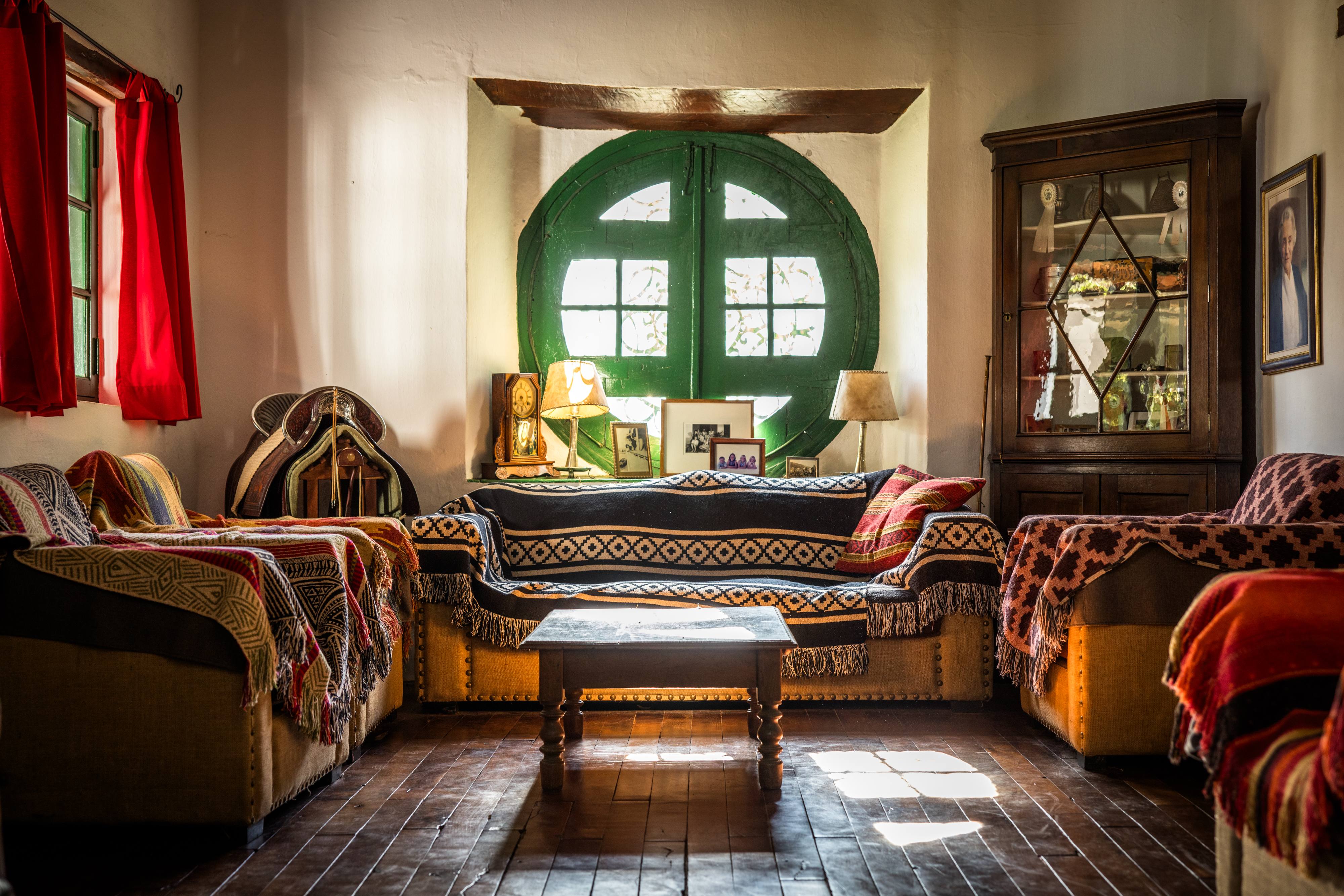 A cozy estancia sitting room in Argentina with sofas draped in colorful woven Andean textiles