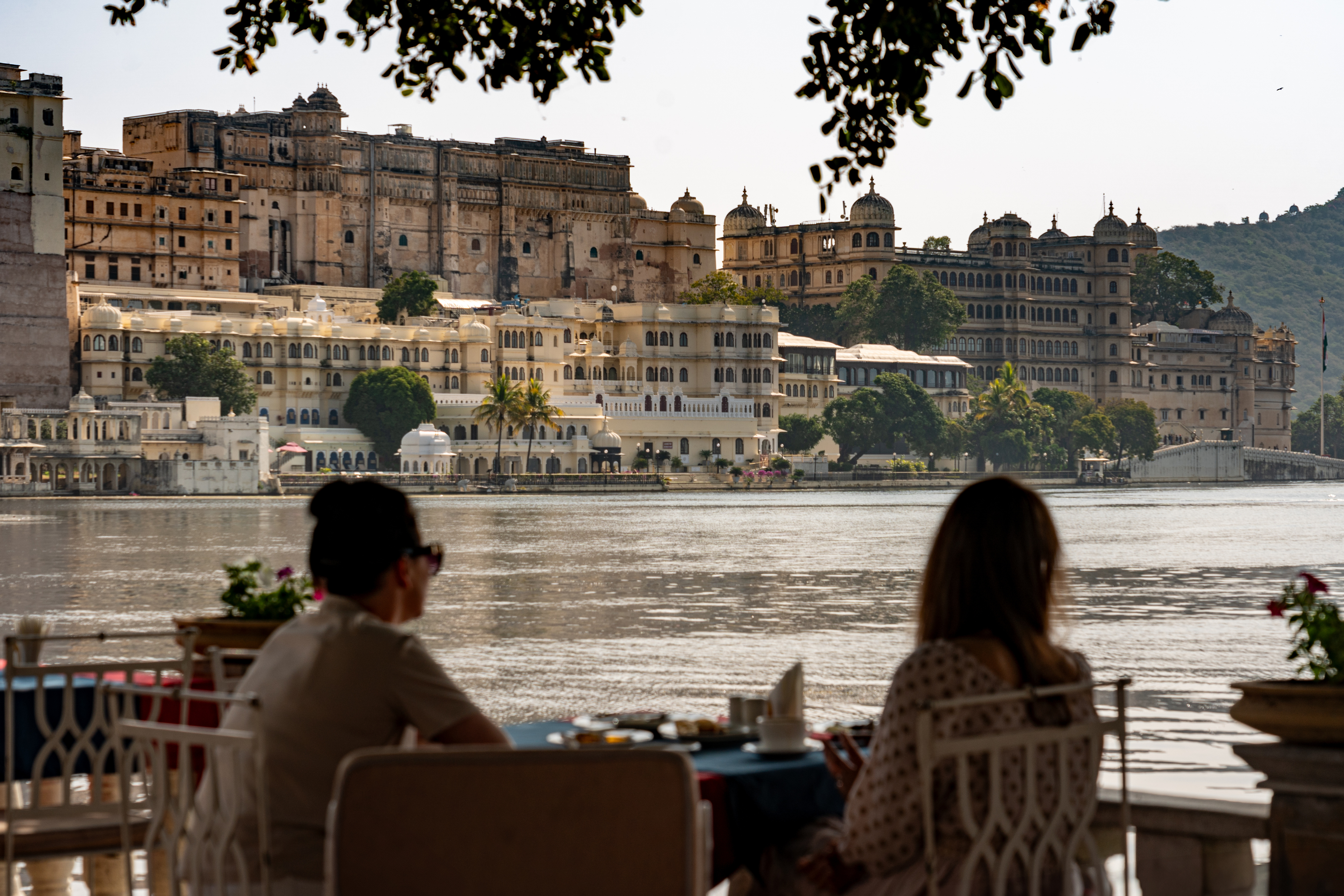 Couple dining with City Palace view across Lake Pichola, Udaipur