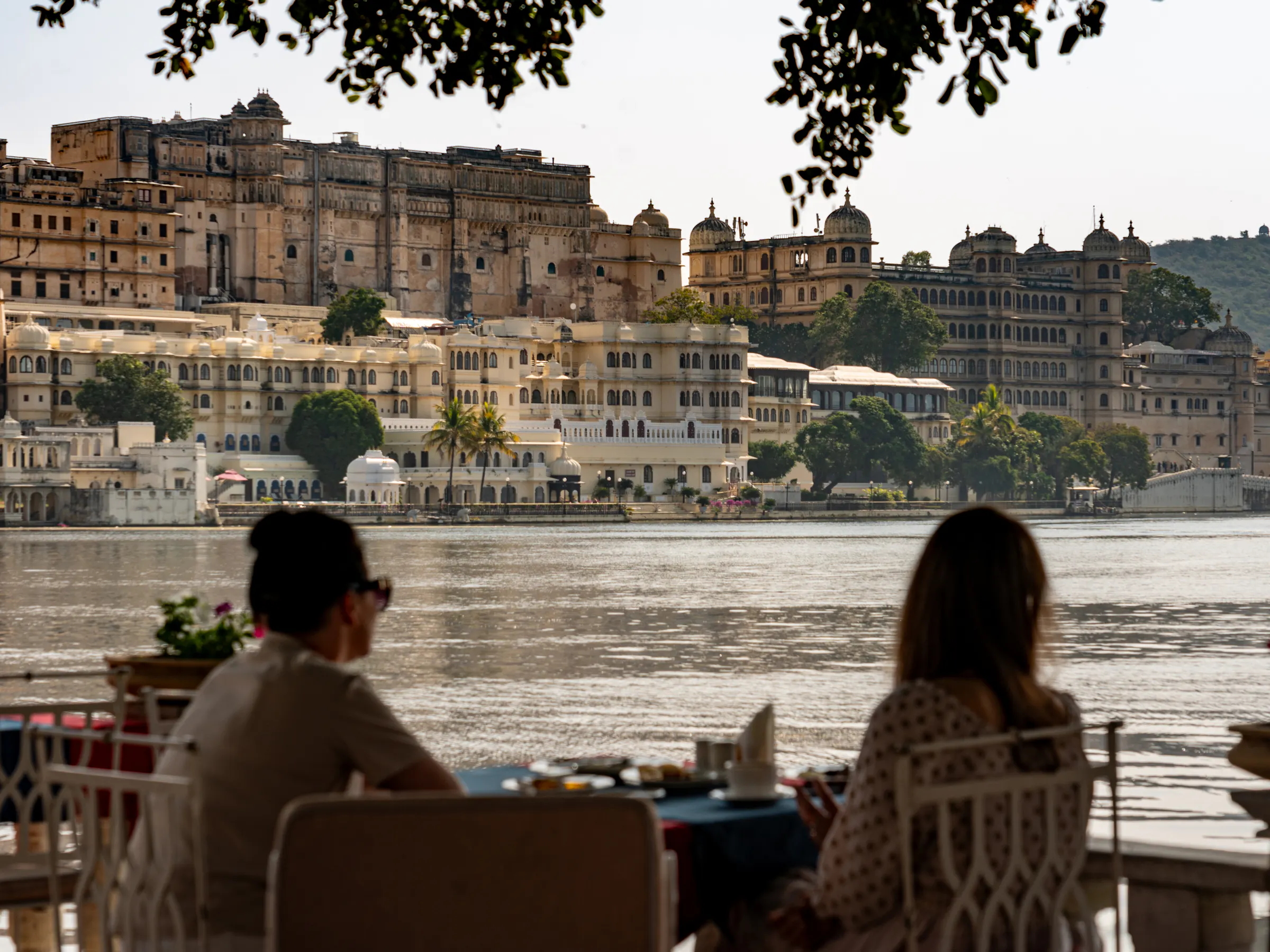 Couple dining with City Palace view across Lake Pichola, Udaipur