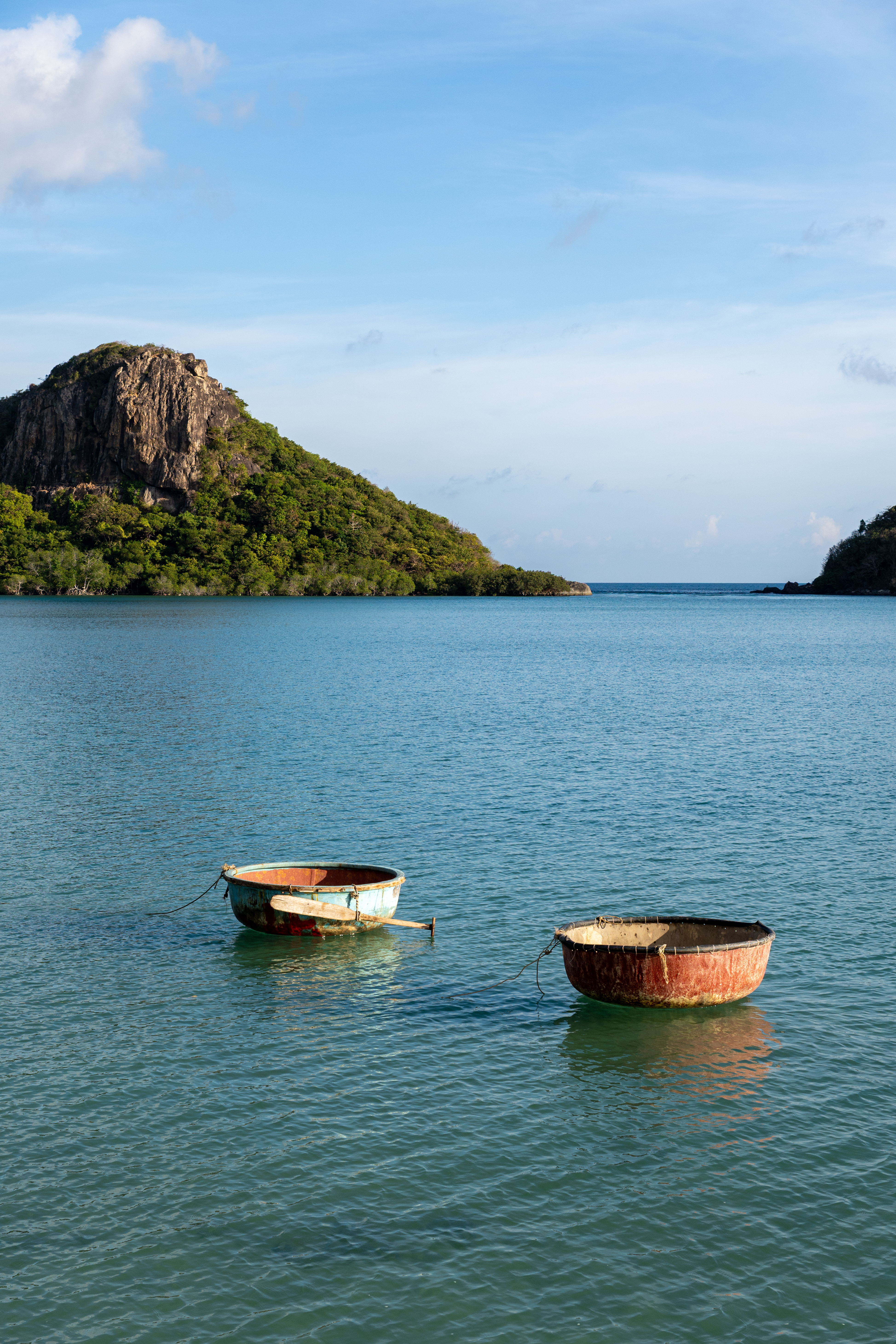 Two traditional basket boats floating in turquoise bay, Con Dao Vietnam