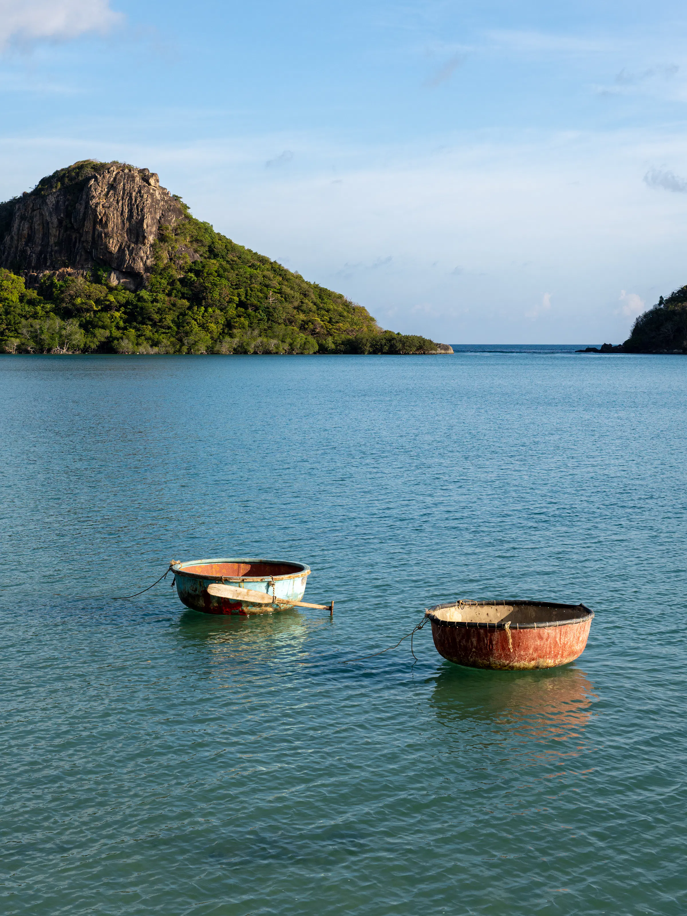 Two traditional basket boats floating in turquoise bay, Con Dao Vietnam