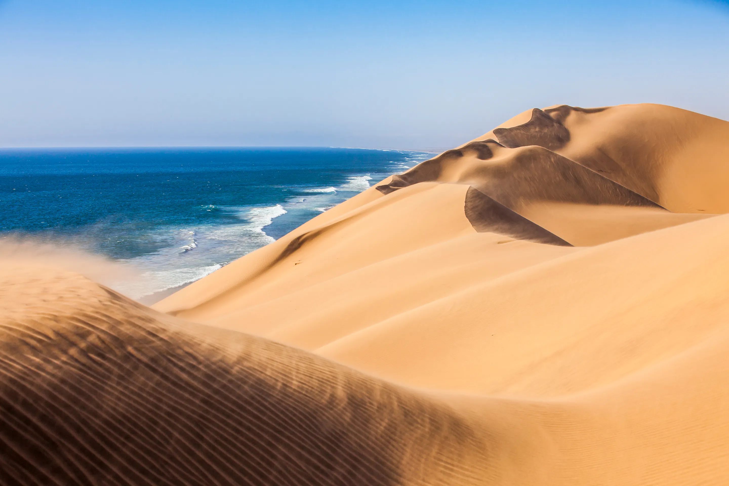 Namib Desert sand dunes meeting Atlantic Ocean, Sandwich Harbour Namibia
