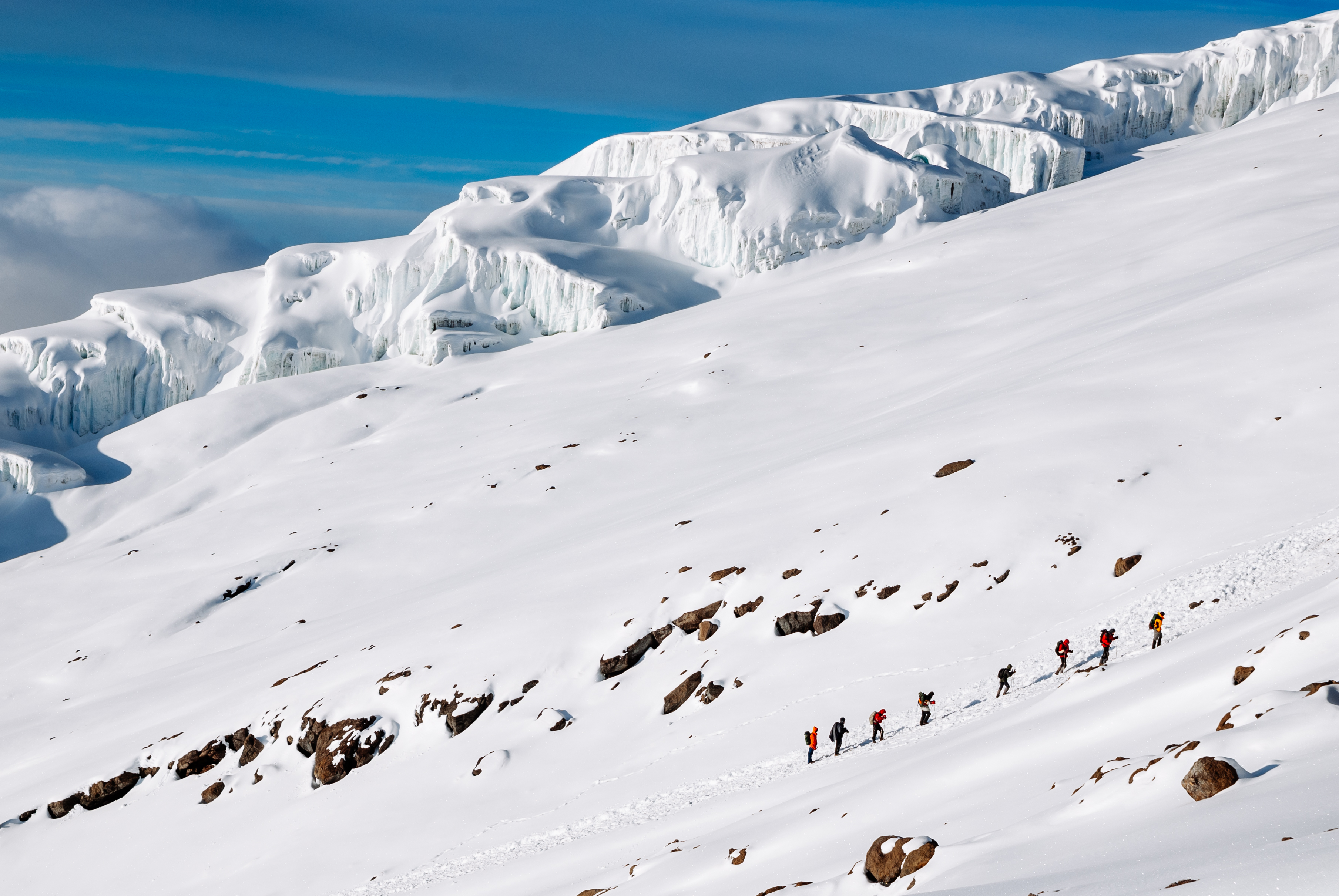 Hikers on trail toward snow-capped Mount Kilimanjaro, Tanzania