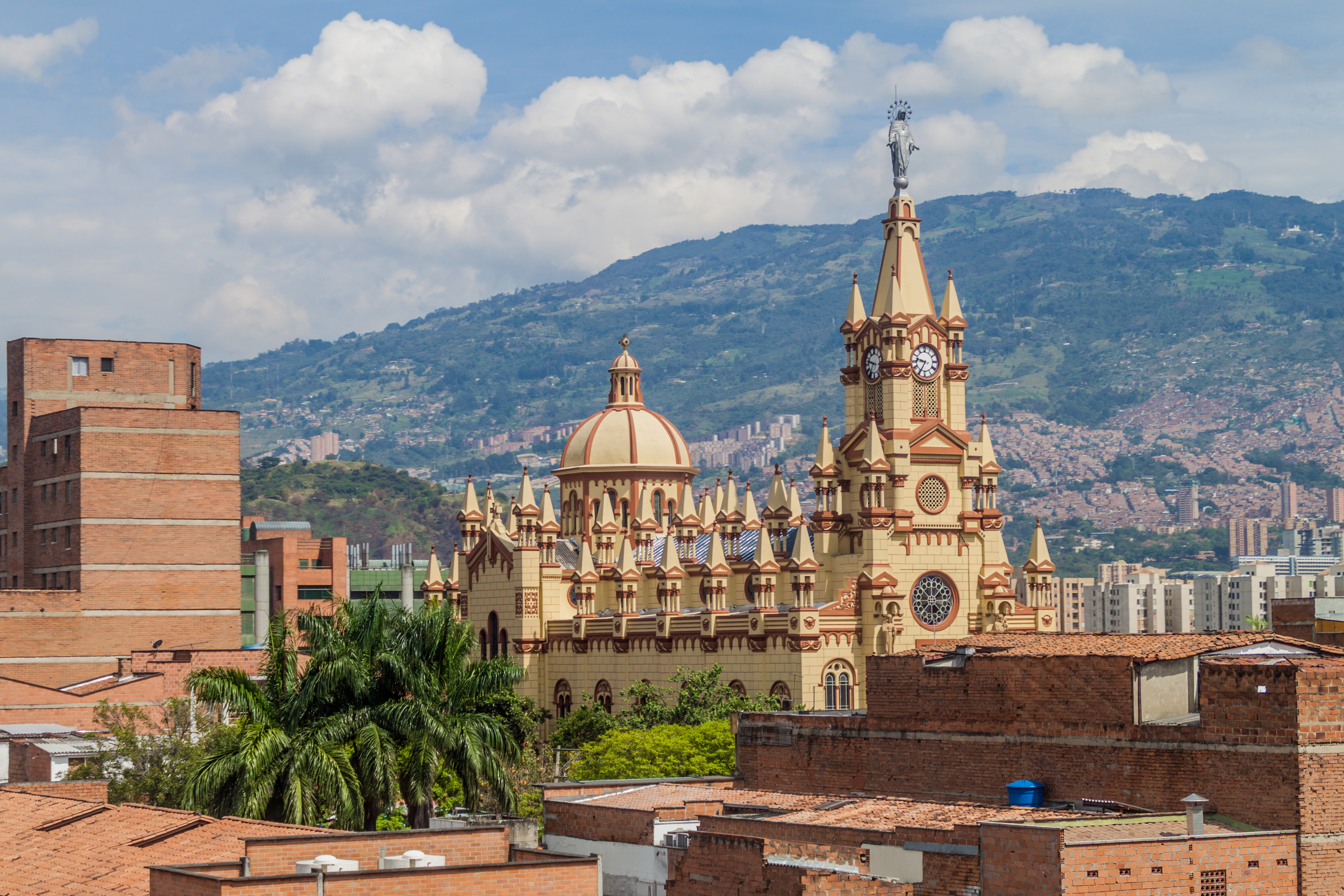 Ornate church towers overlooking rooftops and mountains in Medellín, Colombia