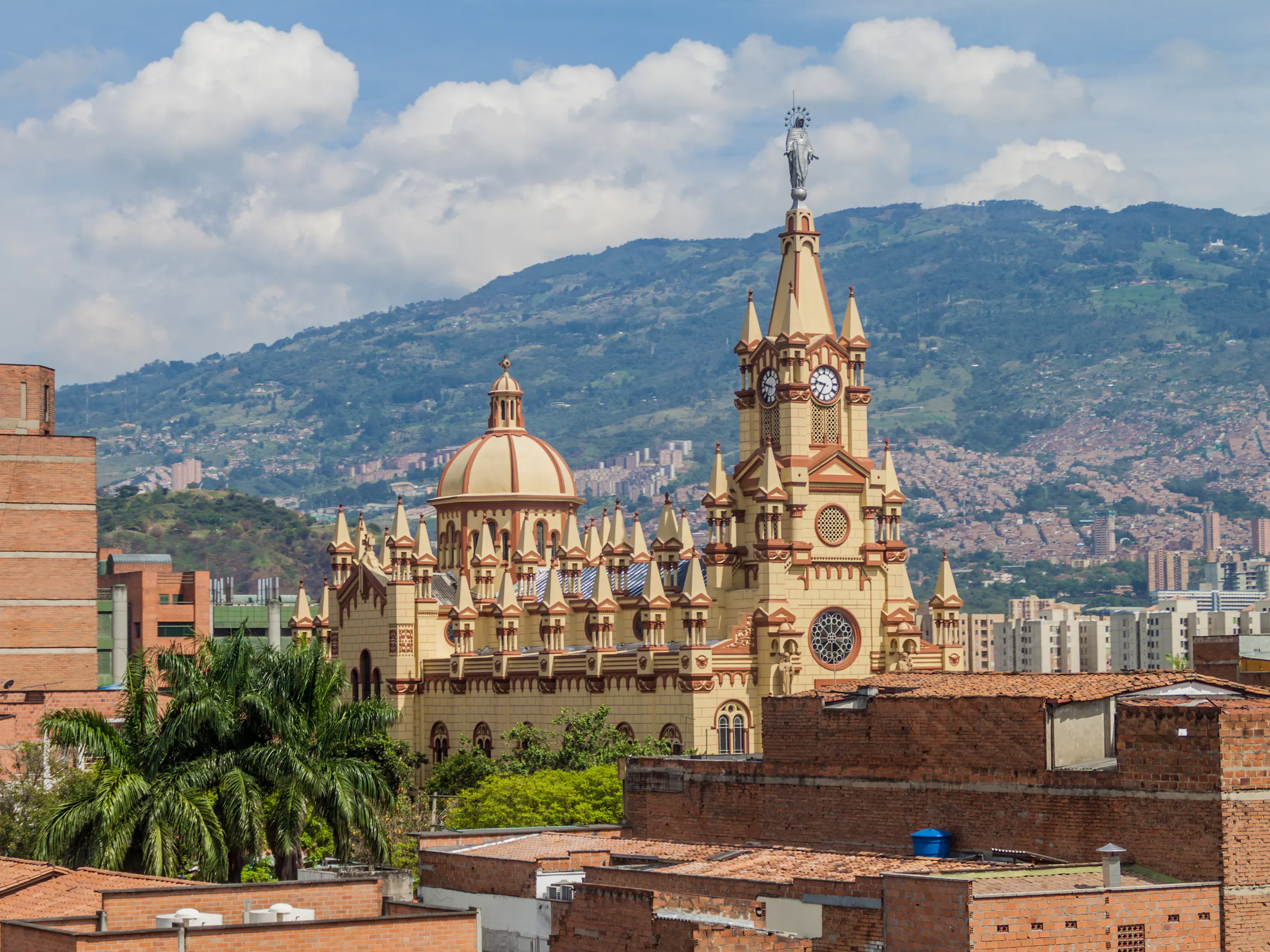 Ornate church towers overlooking rooftops and mountains in Medellín, Colombia