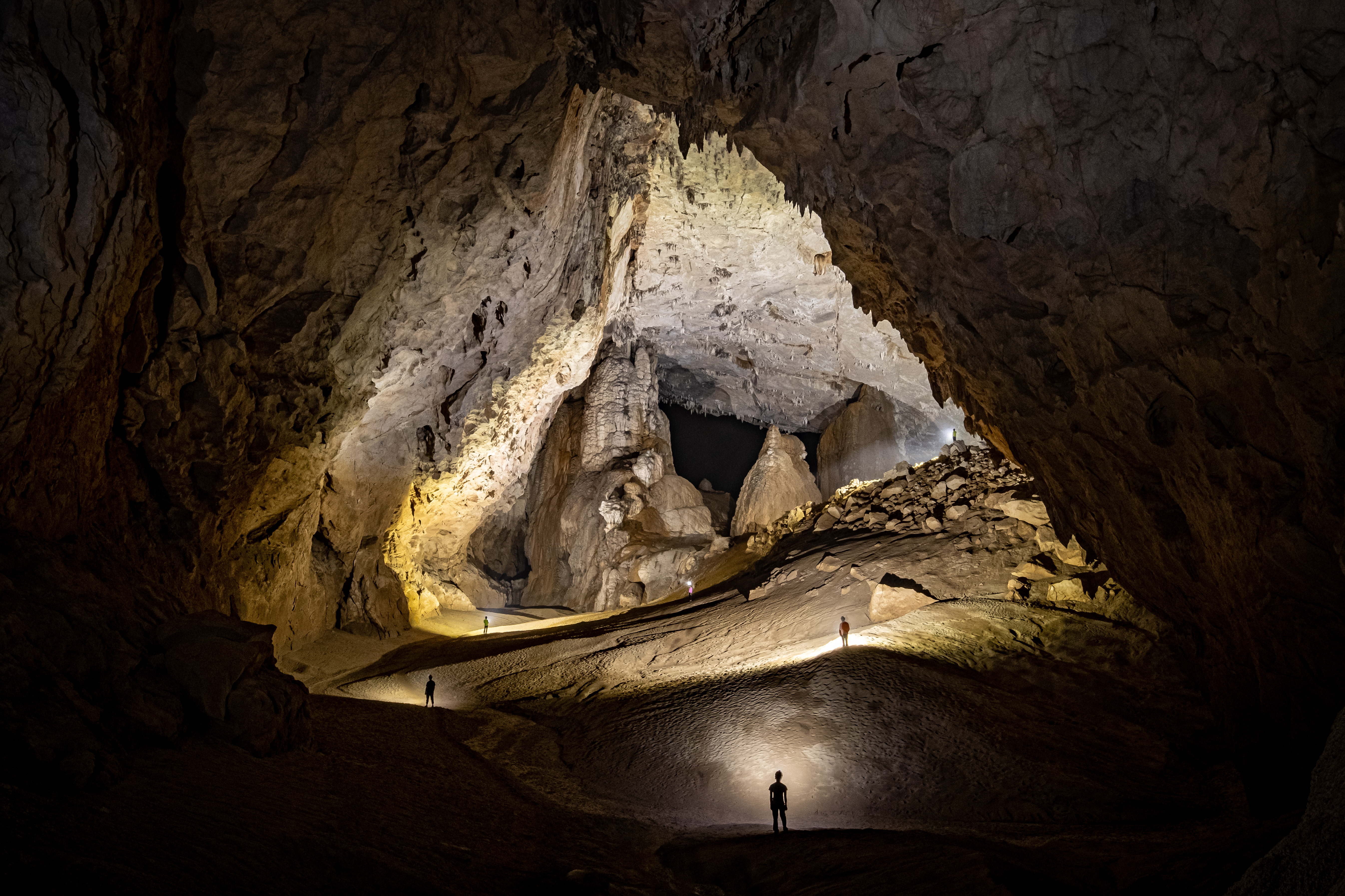 Sunbeam streaming into Son Doong cave with mossy rocks, Vietnam