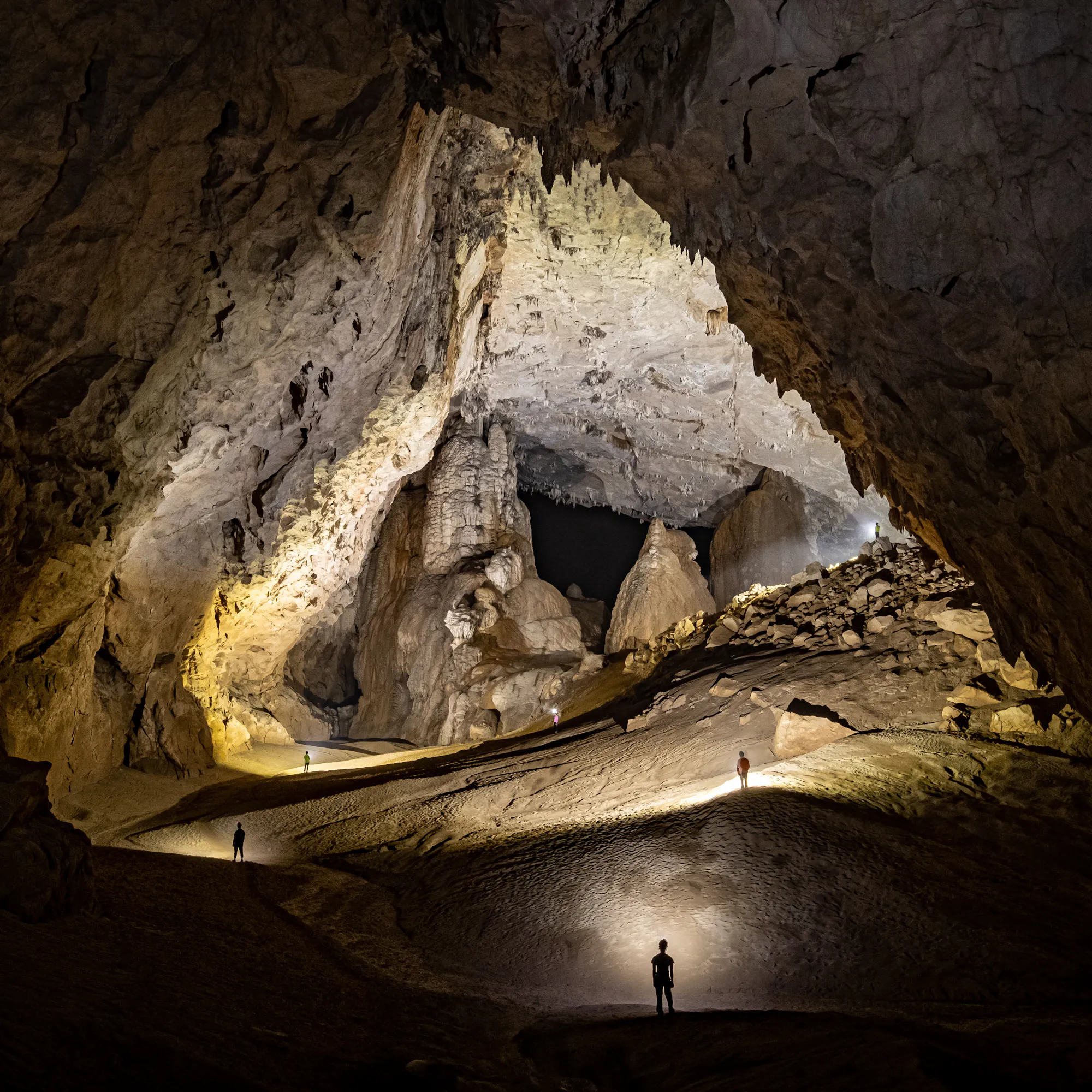 Sunbeam streaming into Son Doong cave with mossy rocks, Vietnam