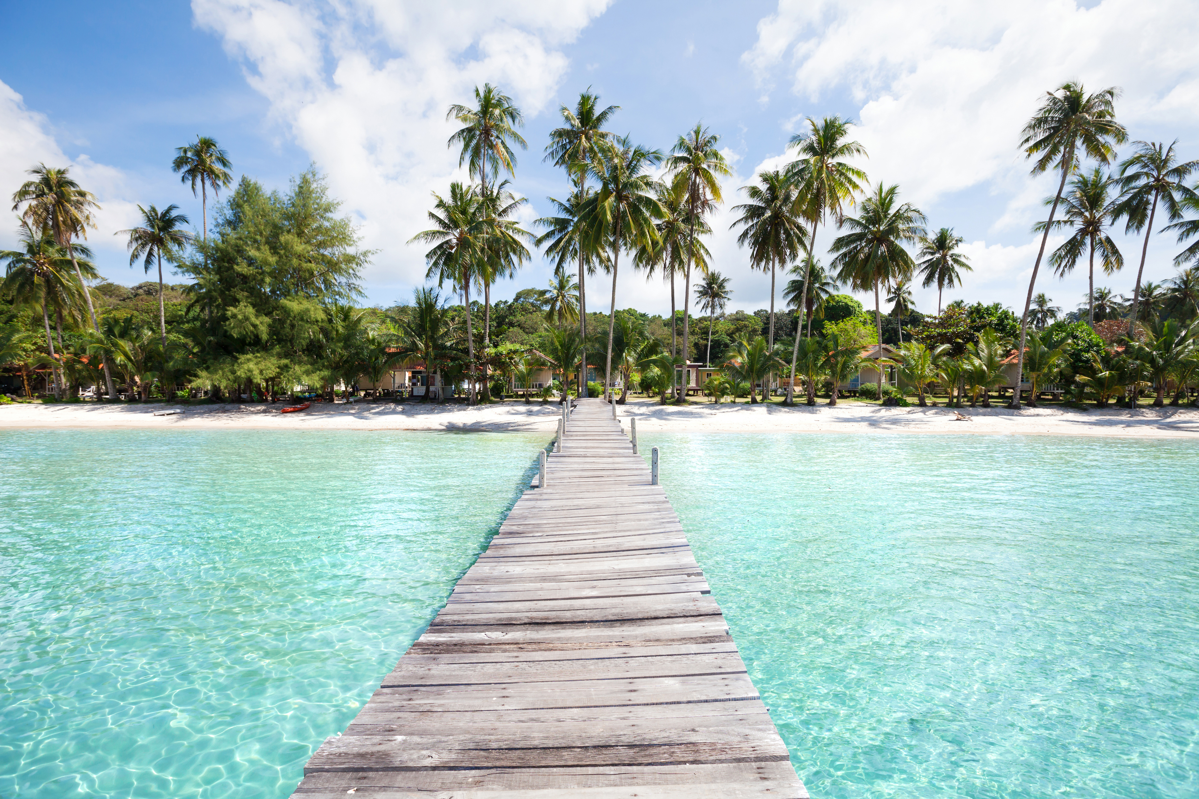 Wooden pier over turquoise water, tropical island beach resort