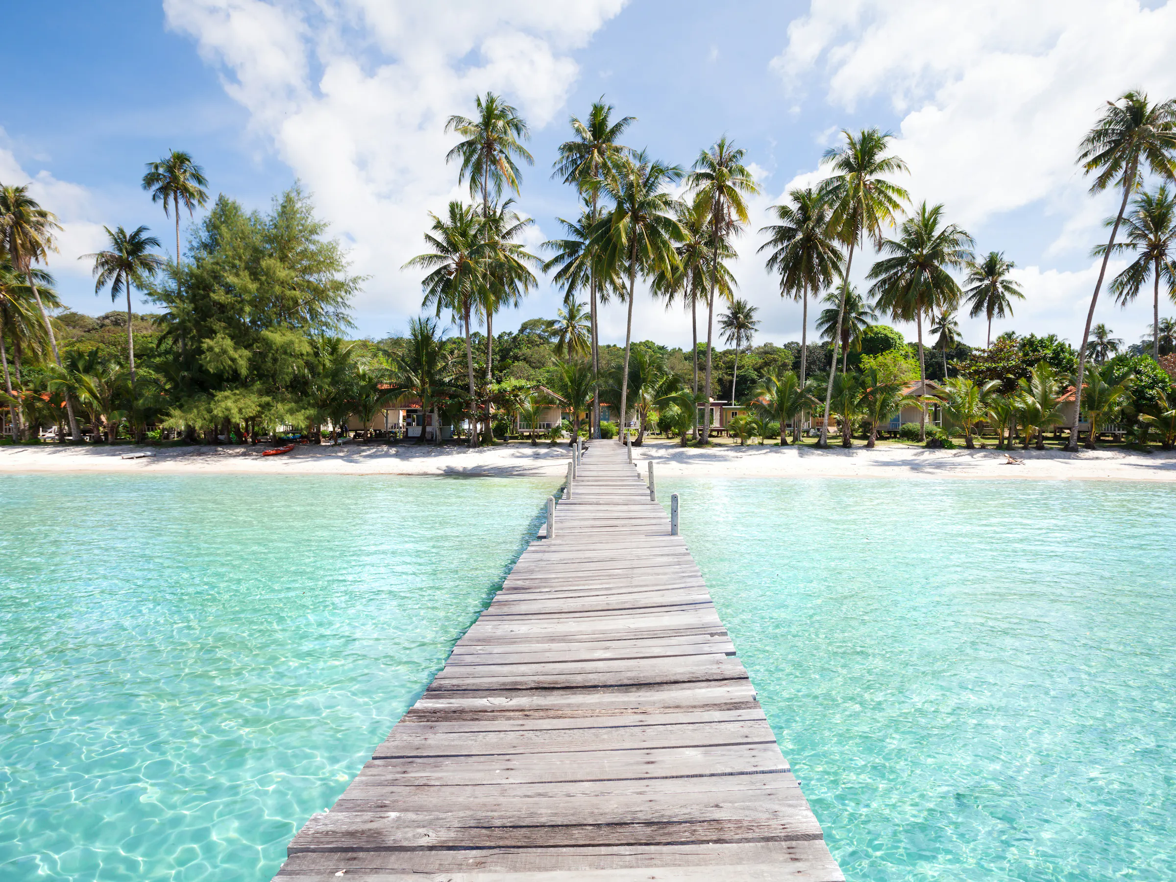 Wooden pier over turquoise water, tropical island beach resort