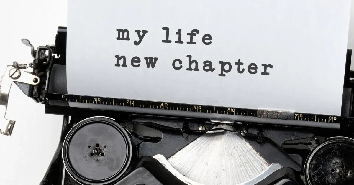Close up of typewriter with paper rolling out and text, "my life new chapter."