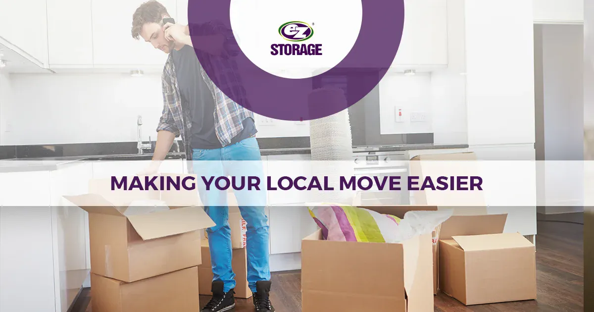 Man on his cellphone unpacking boxes in the kitchen and text "Making your local move easier"