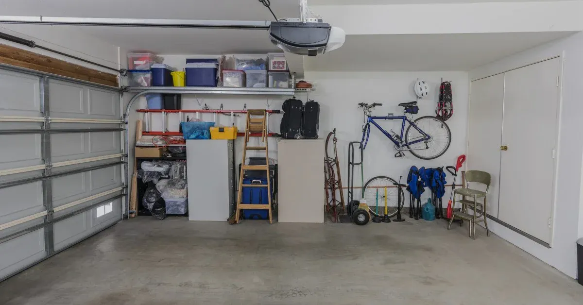 Organized garage with white drywall, shelving units, and wall hangings