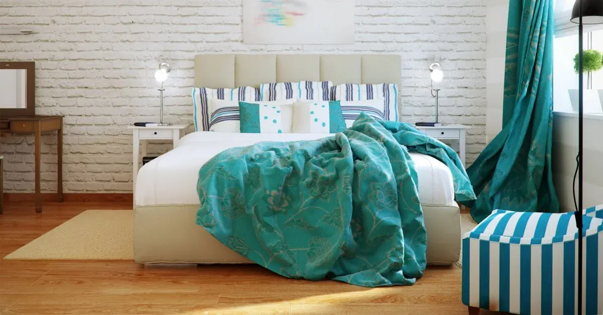 Bedroom scene in efficiency apartment with exposed brick wall and teal & white color scheme