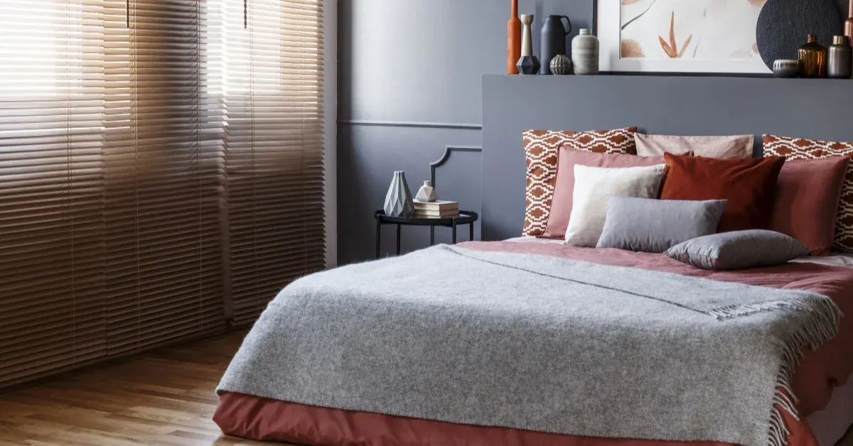 A bedroom view of a bed with decorated pillows and a nightstand