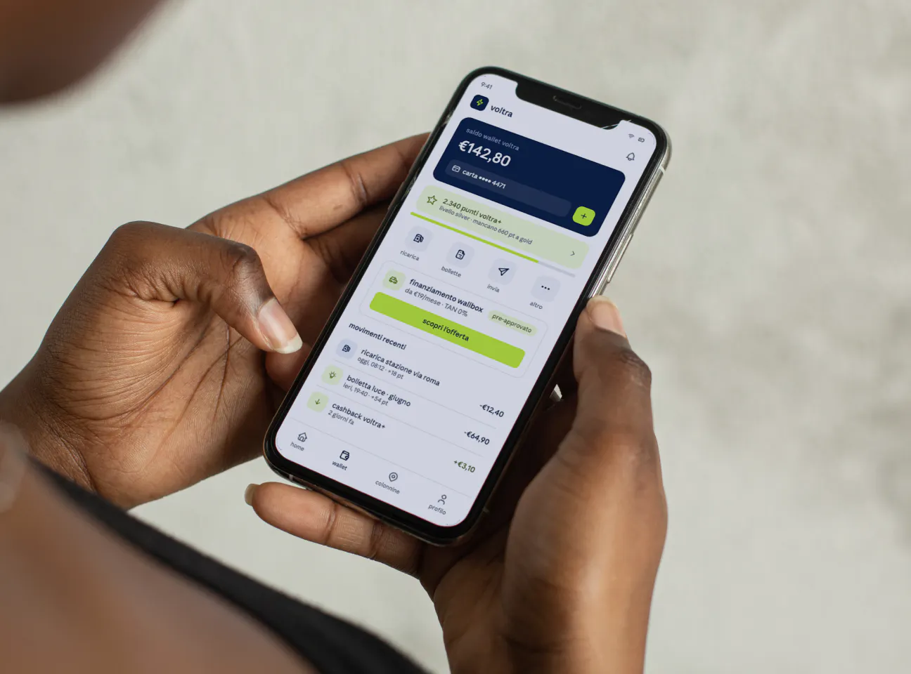 Persona utilizza sullo smartphone un wallet digitale con saldo, pagamenti, cashback e punti fedeltà.