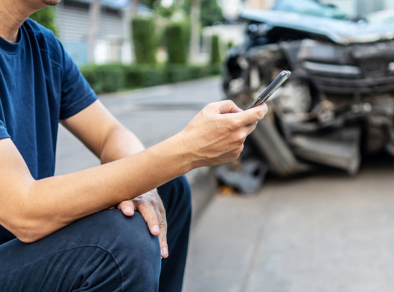 Conductor gestionando un siniestro de coche desde el móvil