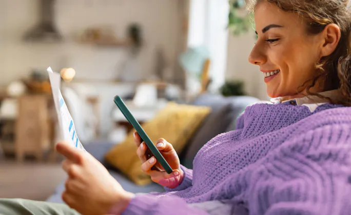 Ragazza che effettua un pagamento inquadrando un documento con lo smarphone