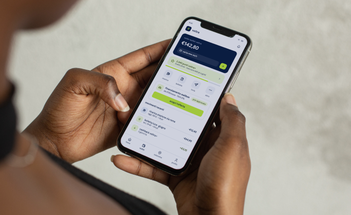 Persona utilizza sullo smartphone un wallet digitale con saldo, pagamenti, cashback e punti fedeltà.