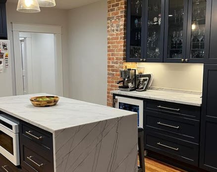 black cabinets and a brick accent wall