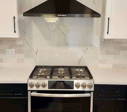 black cabinets with an iridescent white backsplash