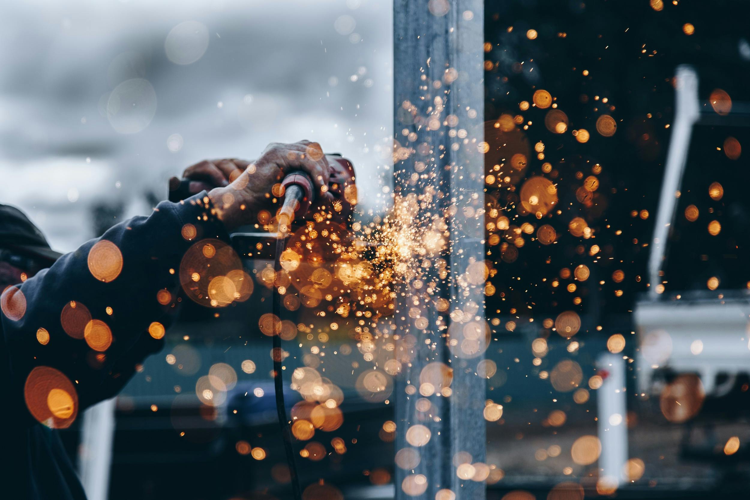 Industrial worker's hands with sparks that look like bokeh